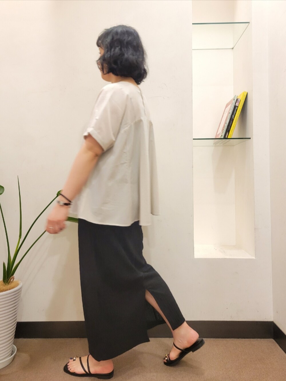 グレー系のシャツ/ブラウス、ブラック系のスカート、ホワイト系のハンドバッグを着用したレディースの夏コーディネートの5枚目の写真