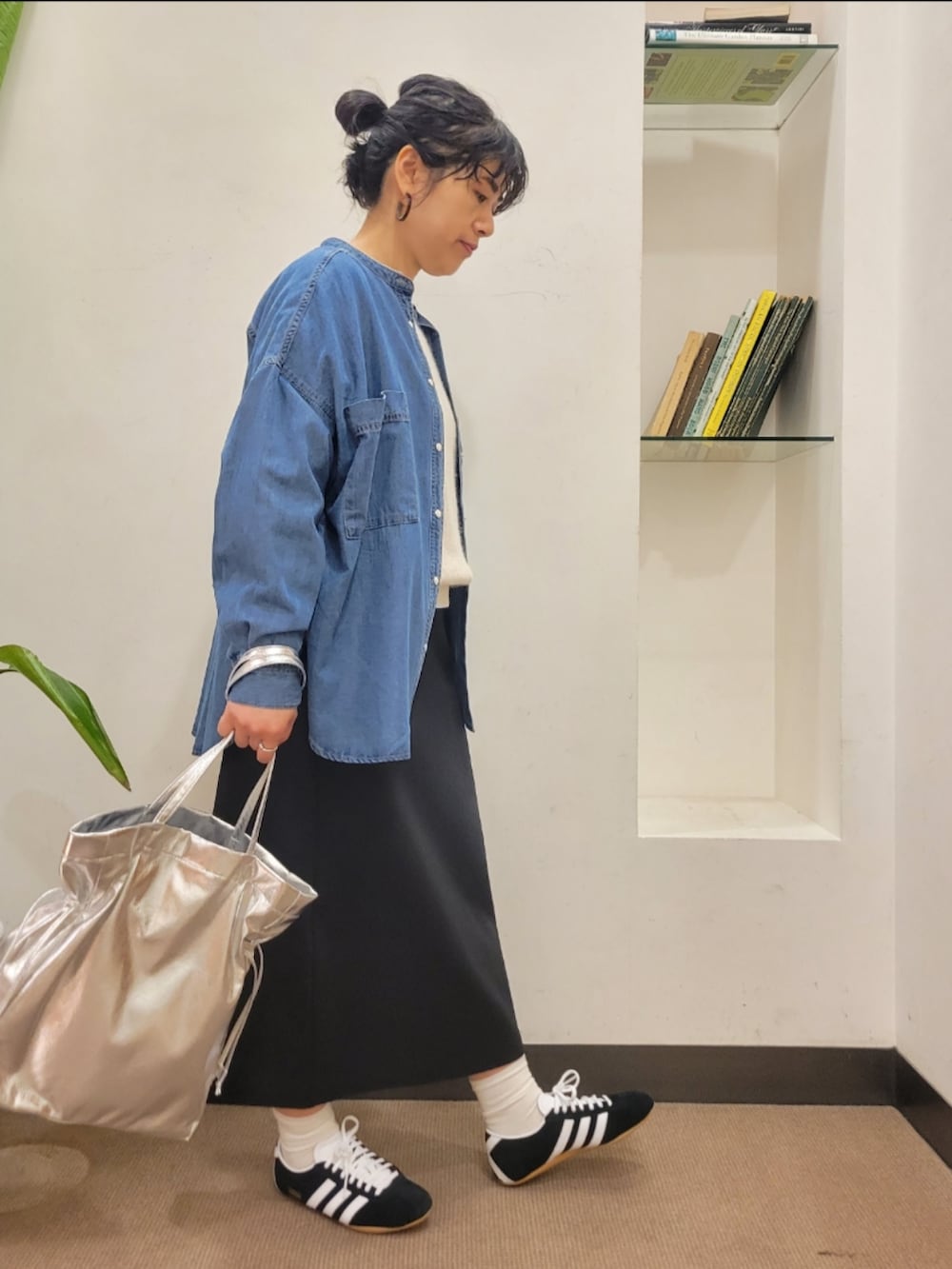 シルバー系のトートバッグ、ブルー系のシャツ/ブラウス、ブラック系のスカートを着用したレディースの冬コーディネートの2枚目の写真