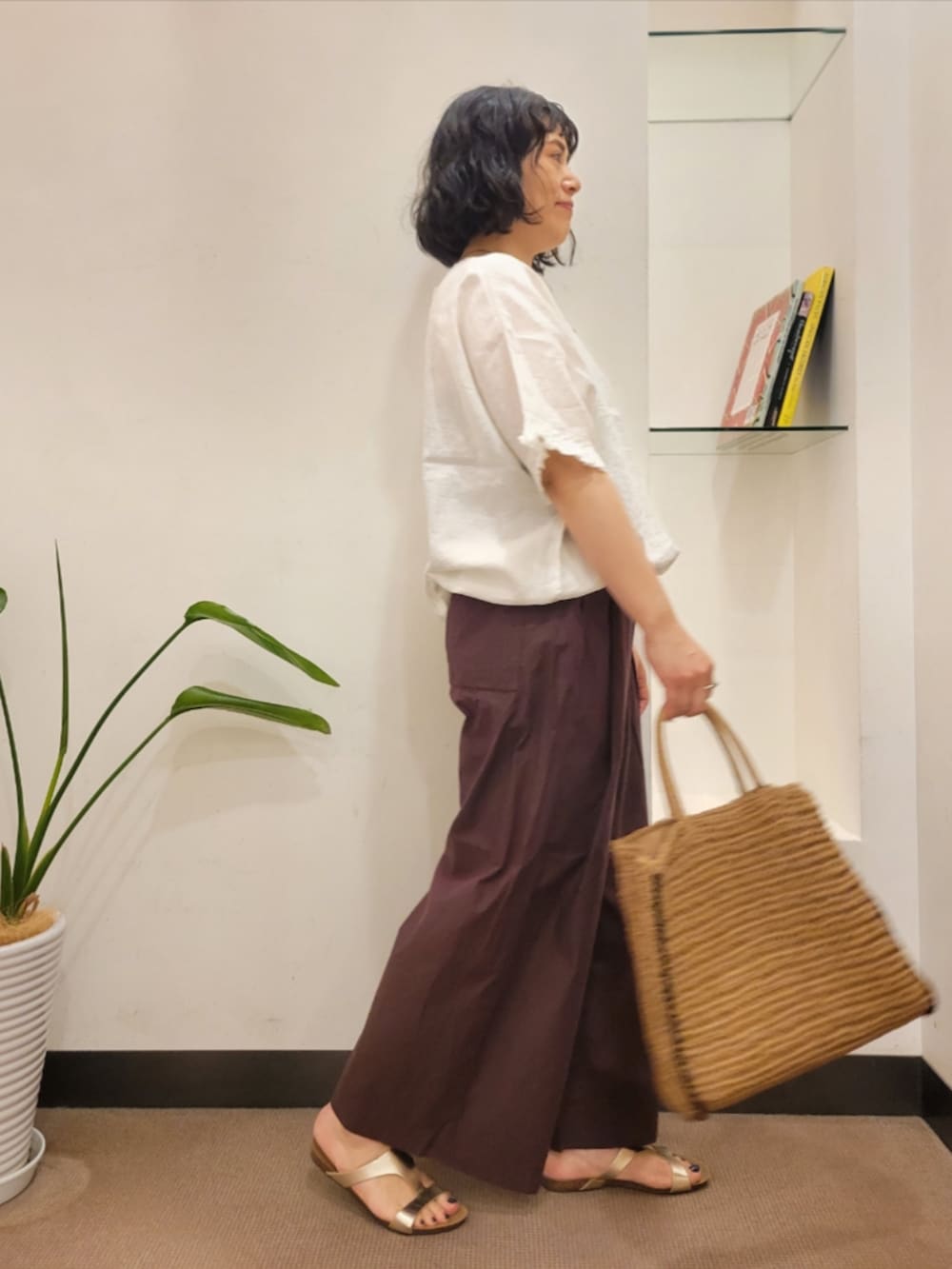 ベージュ系のトートバッグ、ゴールド系のサンダル、ブラウン系のその他パンツを着用したレディースの夏コーディネートの4枚目の写真