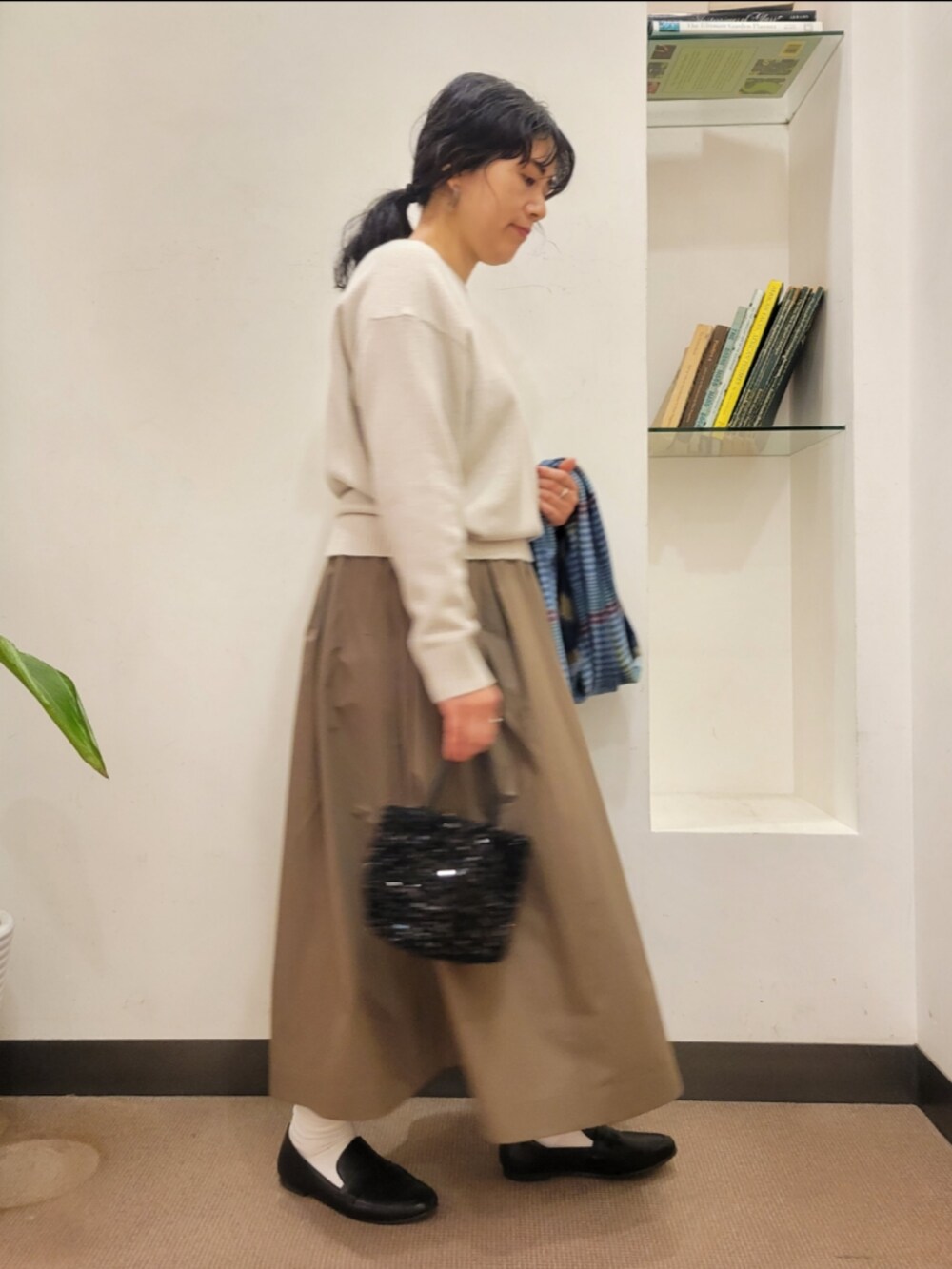 ブラック系のローファー、ブラック系のショルダーバッグ、ベージュ系のニット/セーターを着用したレディースの冬コーディネートの2枚目の写真