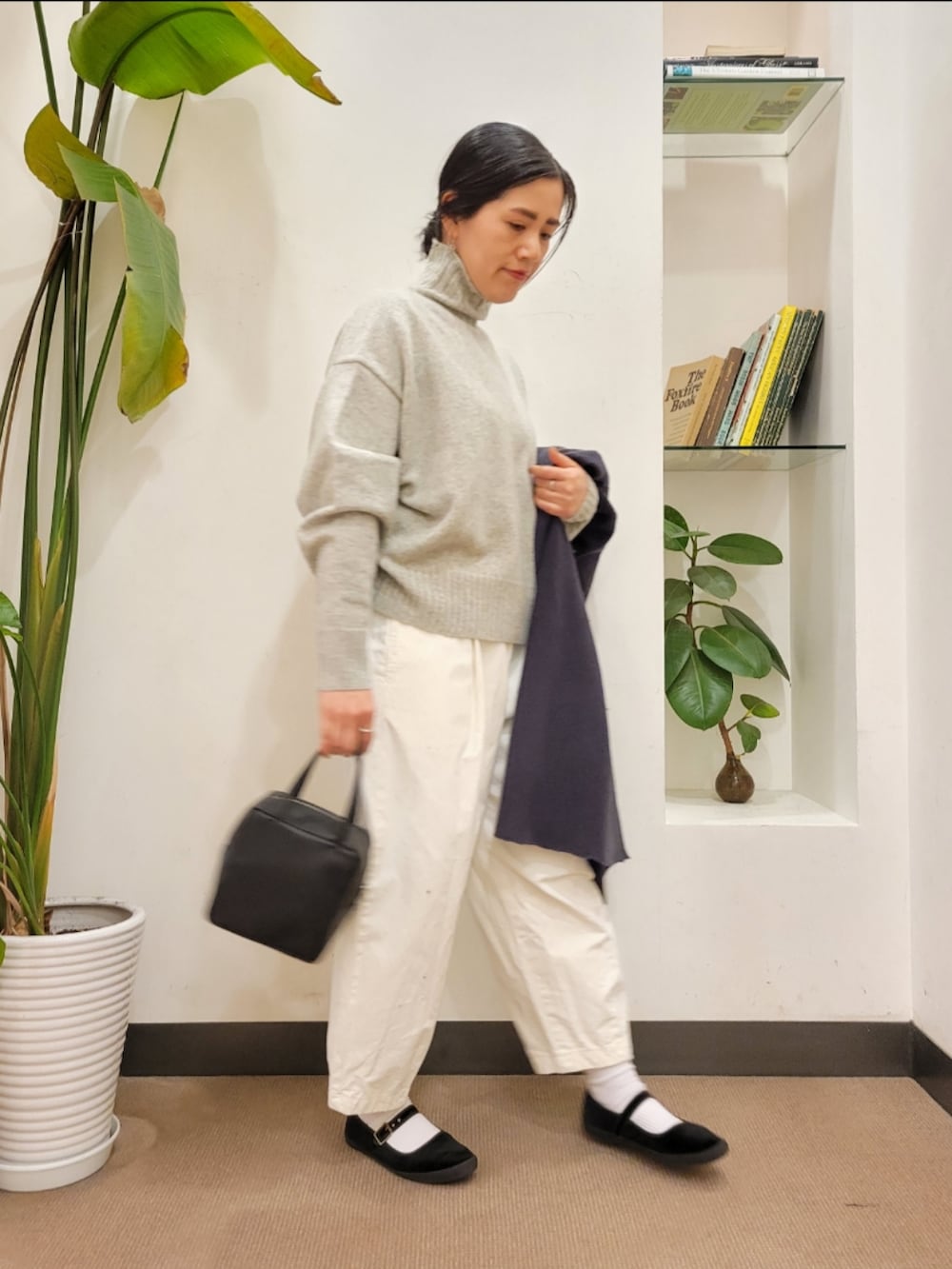 グレー系のノーカラーコート、ホワイト系のその他パンツ、グレー系のニット/セーターを着用したレディースの冬コーディネートの5枚目の写真