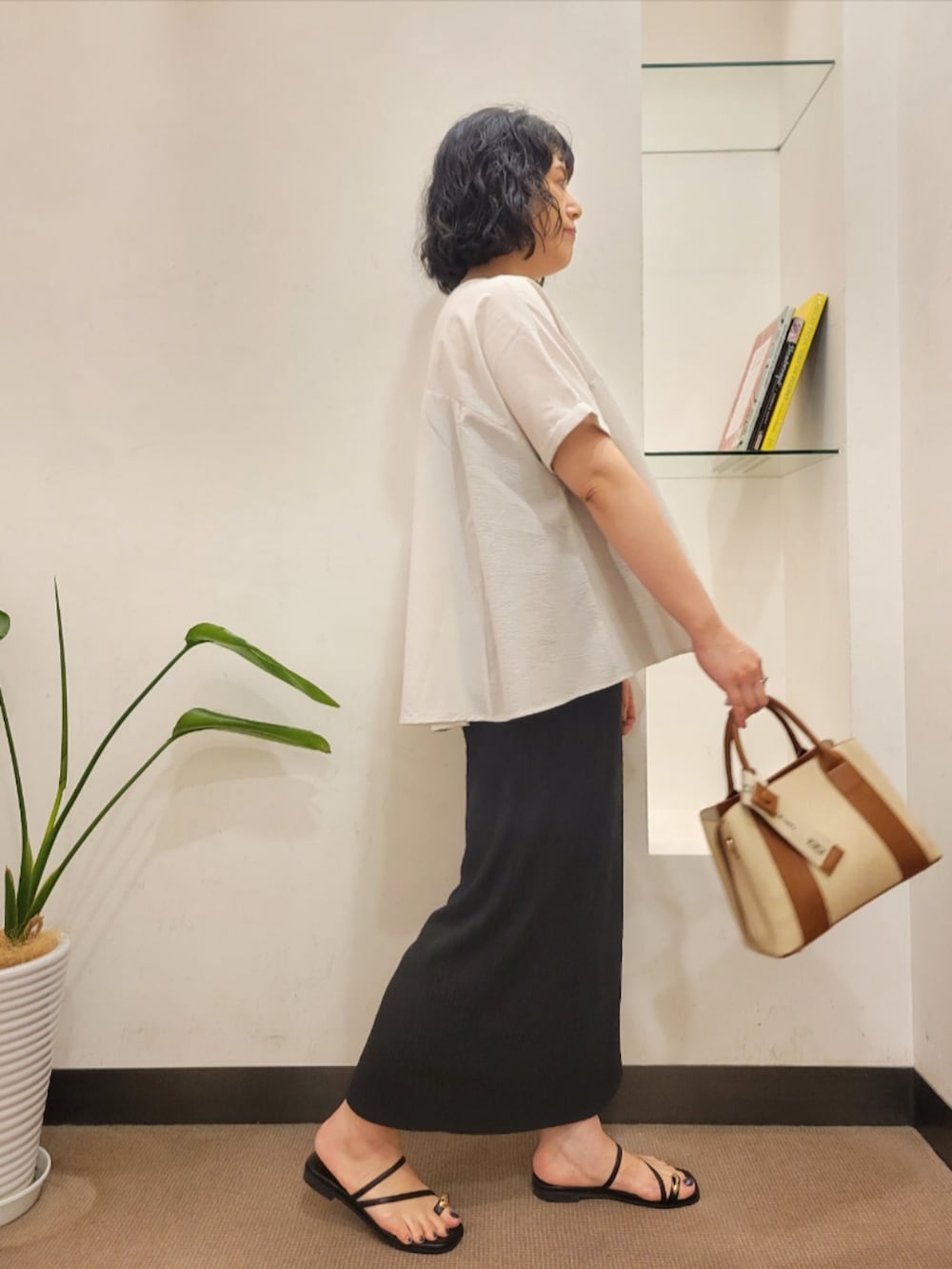 グレー系のシャツ/ブラウス、ブラック系のスカート、ホワイト系のハンドバッグを着用したレディースの夏コーディネートの4枚目の写真