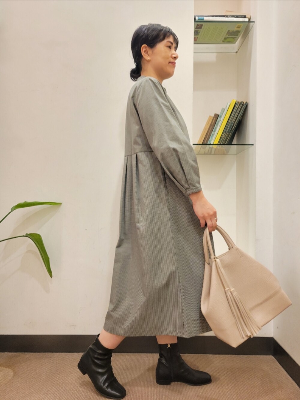 ブラック系のブーツ、グレー系のワンピース、ホワイト系のトートバッグを着用したレディースの秋コーディネートの4枚目の写真