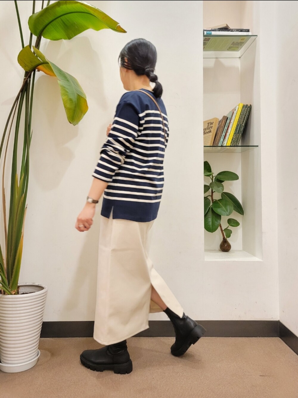 ホワイト系のショルダーバッグ、ブラック系のブーツ、ホワイト系のスカートを着用したレディースの秋コーディネートの4枚目の写真