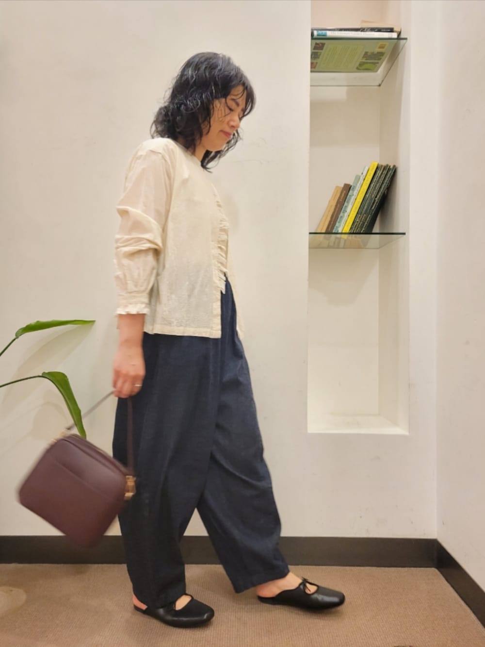 レッド系のショルダーバッグ、ホワイト系のTシャツ/カットソー、ブラック系のサンダルを着用したレディースの秋コーディネートの3枚目の写真