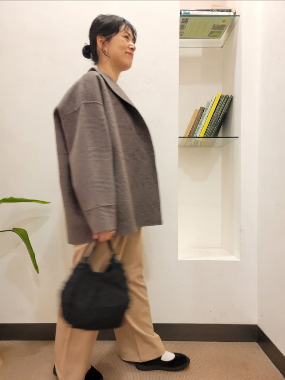 ブラック系のハンドバッグ、その他のその他アウター、ベージュ系のその他パンツを着用したレディースの秋コーディネートの2枚目の写真