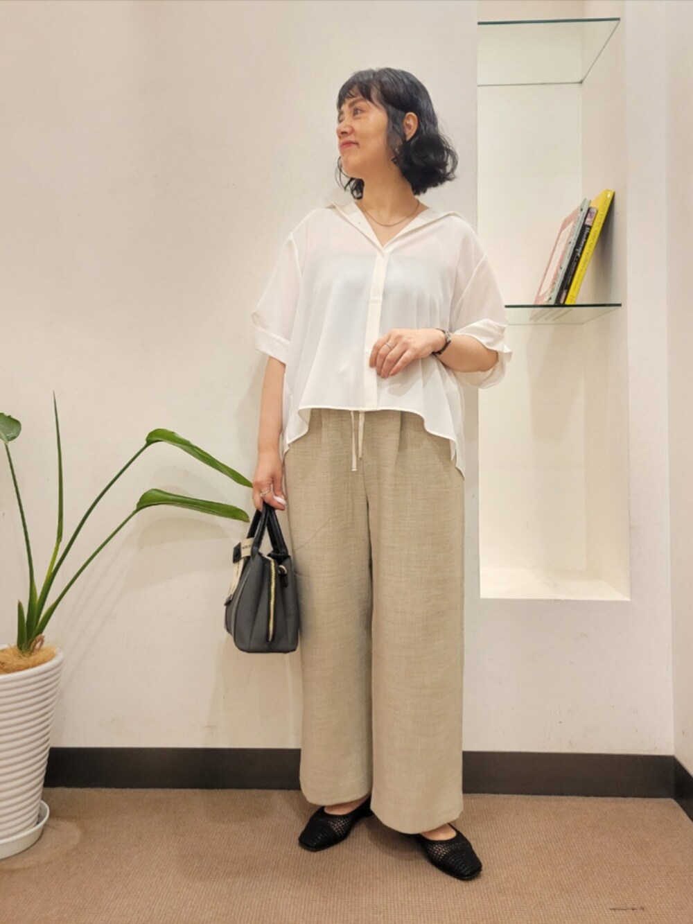 ホワイト系のシャツ/ブラウス、ベージュ系のその他パンツ、ブラック系のハンドバッグを着用したレディースの夏コーディネートの3枚目の写真