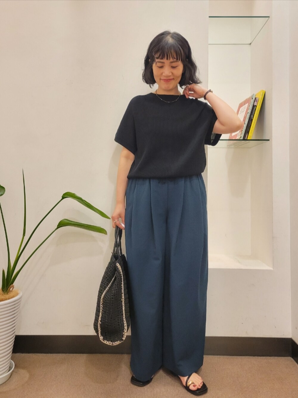 ブラック系のトートバッグ、グリーン系のその他パンツ、ブラック系のニット/セーターを着用したレディースの夏コーディネートの3枚目の写真