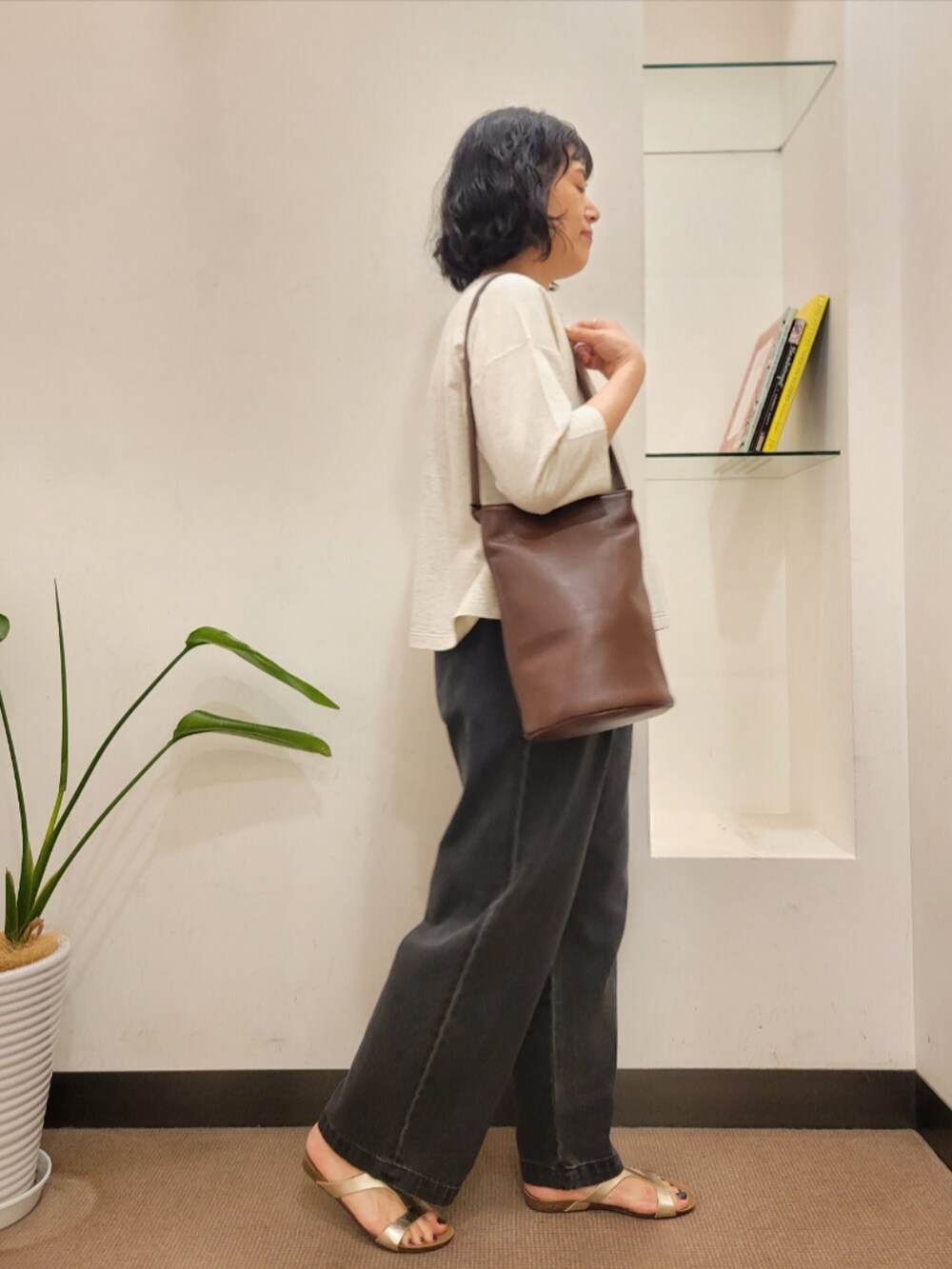 ブラウン系のショルダーバッグ、ゴールド系のサンダル、ブラック系のデニムパンツを着用したレディースの夏コーディネートの4枚目の写真