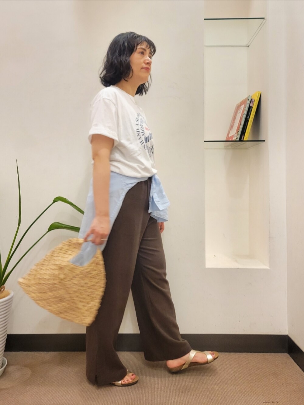 ベージュ系のハンドバッグ、ブルー系のシャツ/ブラウス、ブラウン系のその他パンツを着用したレディースの夏コーディネートの3枚目の写真