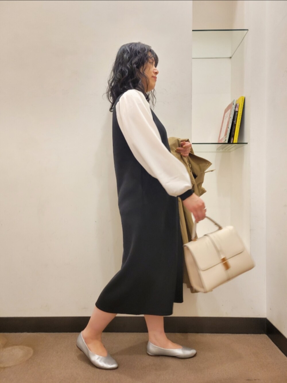 ベージュ系のトレンチコート、ブラック系のワンピース、シルバー系のパンプスを着用したレディースの冬コーディネートの5枚目の写真
