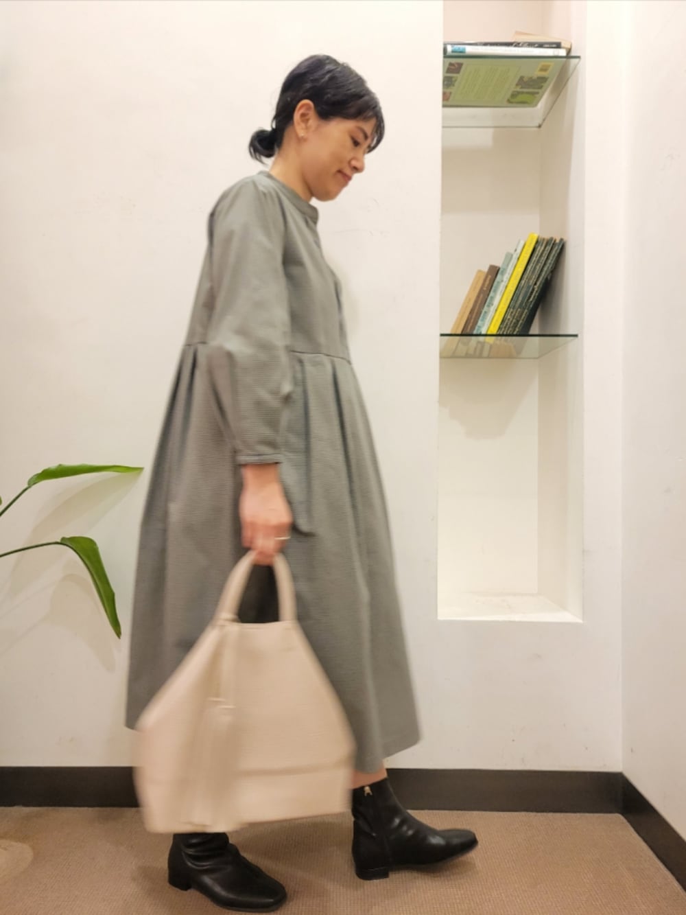 ブラック系のブーツ、グレー系のワンピース、ホワイト系のトートバッグを着用したレディースの秋コーディネートの3枚目の写真