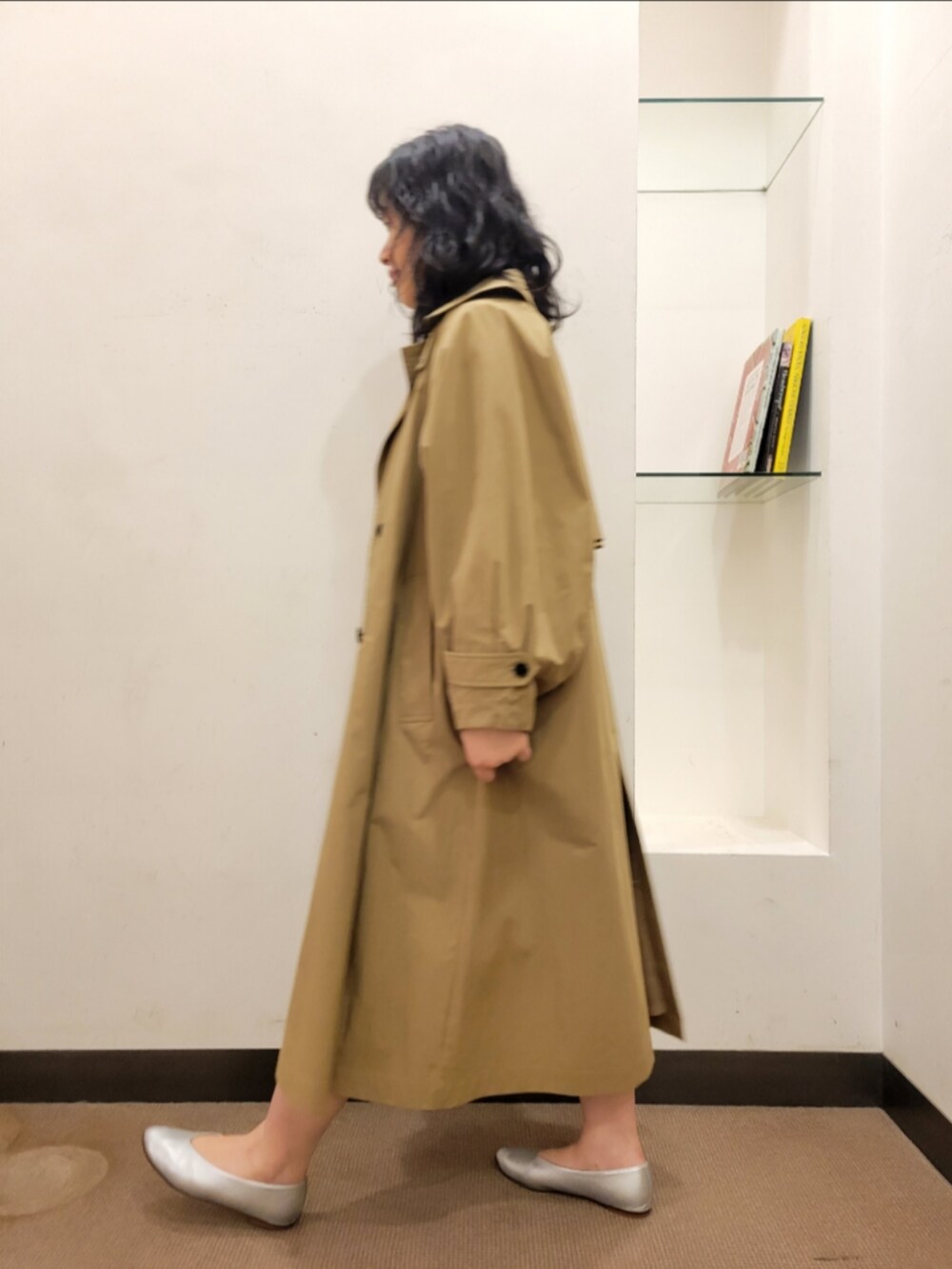 ベージュ系のトレンチコート、ブラック系のワンピース、シルバー系のパンプスを着用したレディースの冬コーディネートの3枚目の写真