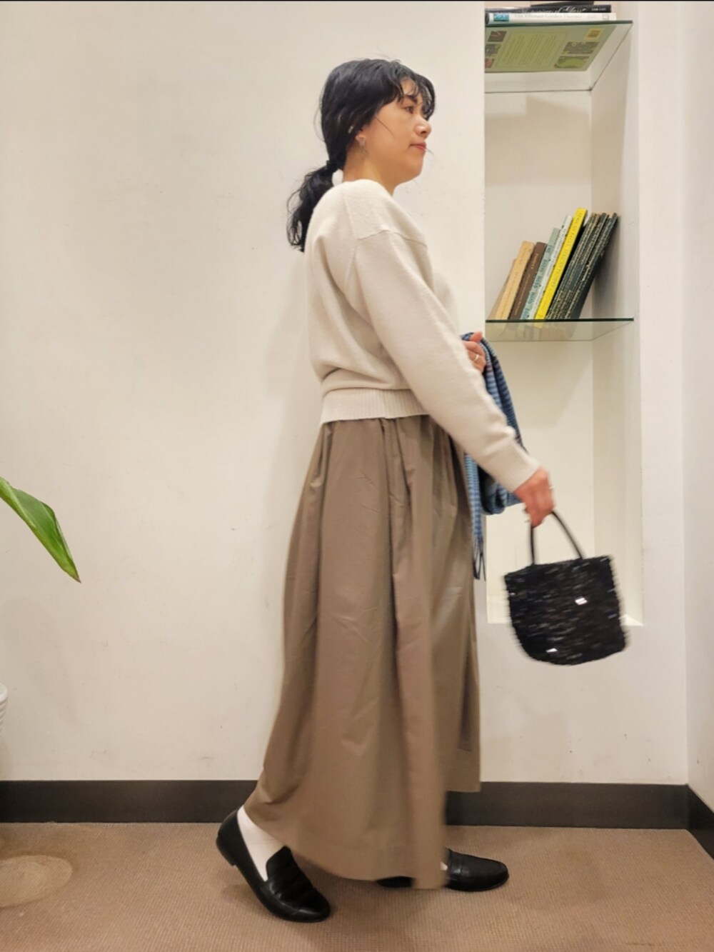 ブラック系のローファー、ブラック系のショルダーバッグ、ベージュ系のニット/セーターを着用したレディースの冬コーディネートの3枚目の写真