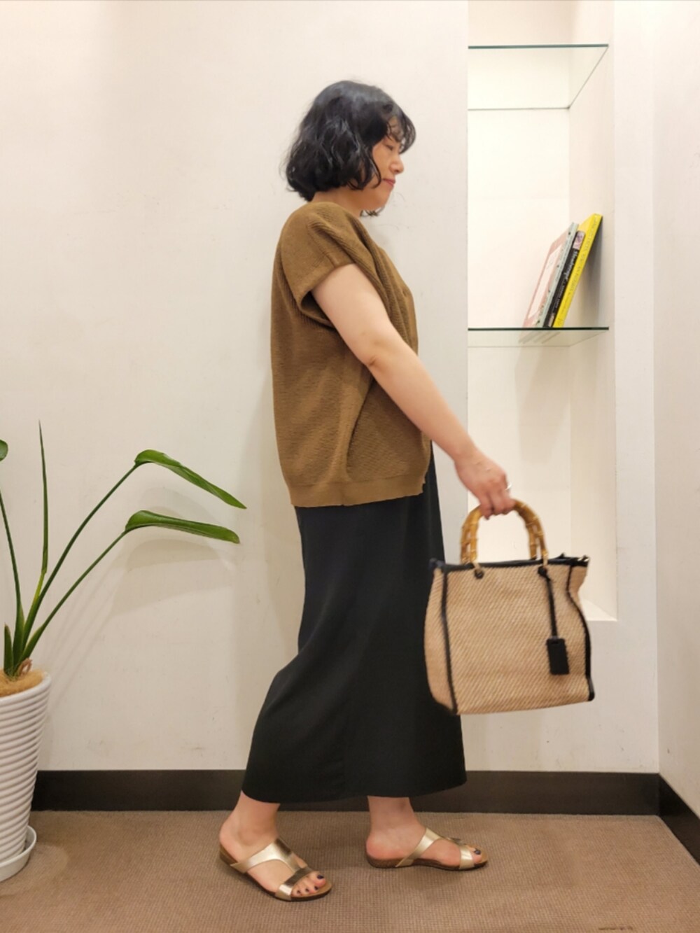ブラック系のワンピース、ブラウン系のベスト、ブラック系のショルダーバッグを着用したレディースの夏コーディネートの3枚目の写真