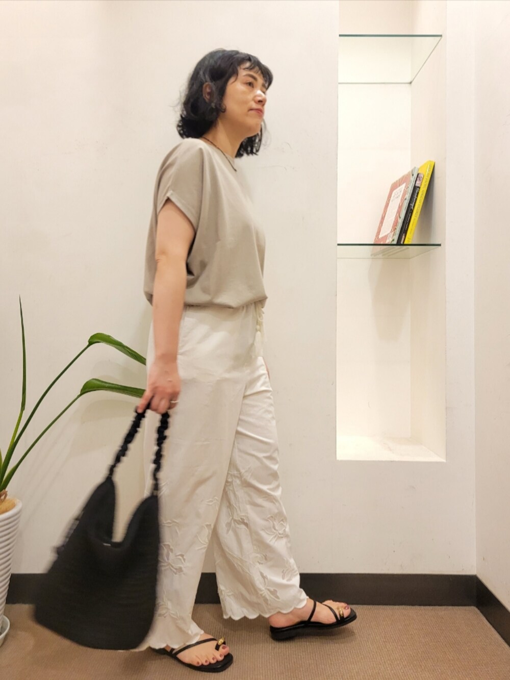 グレー系のTシャツ/カットソー、ホワイト系のその他パンツ、ブラック系のショルダーバッグを着用したレディースの夏コーディネートの2枚目の写真