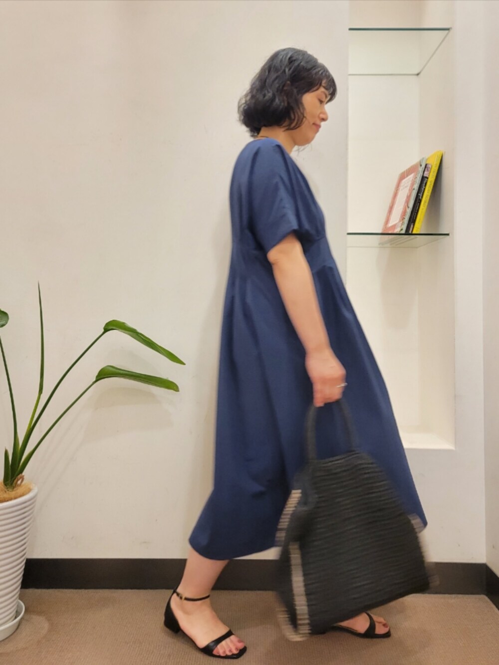 ブラック系のトートバッグ、ブルー系のワンピース、ブラック系のサンダルを着用したレディースの夏コーディネートの3枚目の写真