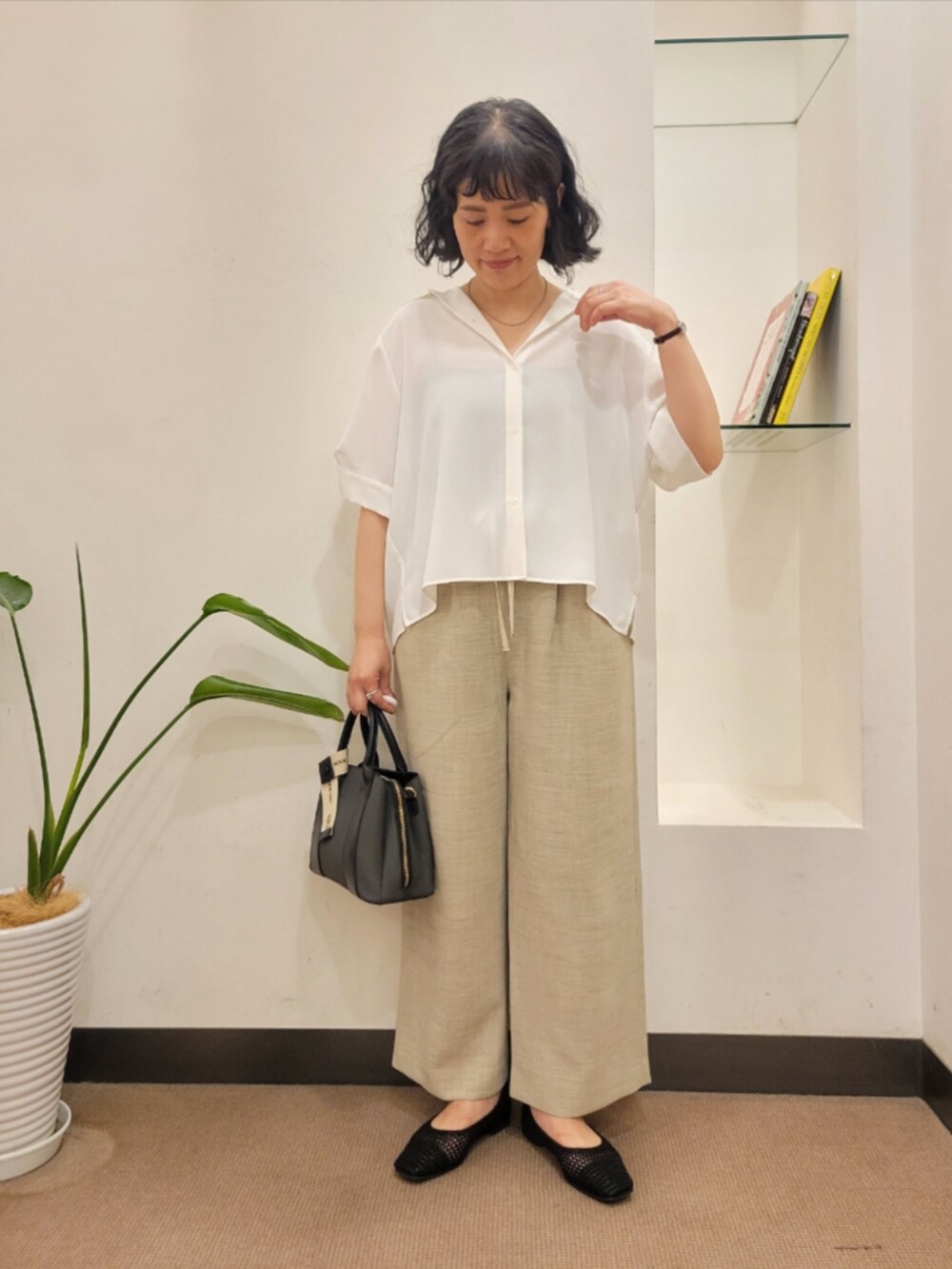 ホワイト系のシャツ/ブラウス、ベージュ系のその他パンツ、ブラック系のハンドバッグを着用したレディースの夏コーディネートの2枚目の写真
