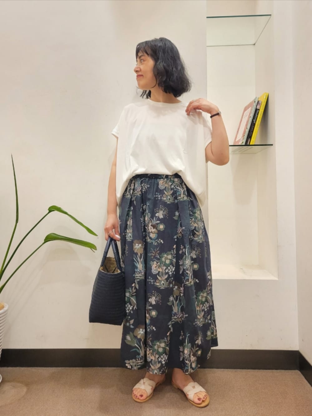 ブルー系のトートバッグ、ホワイト系のTシャツ/カットソー、ホワイト系のサンダルを着用したレディースの夏コーディネートの2枚目の写真