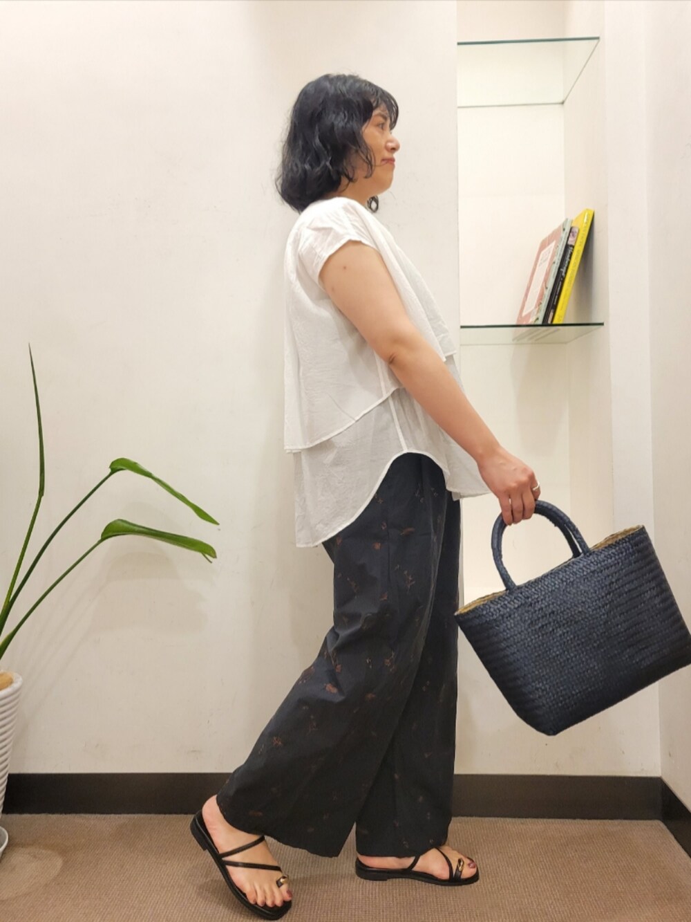 ブルー系のトートバッグ、ホワイト系のシャツ/ブラウス、ブラック系のサンダルを着用したレディースの夏コーディネートの3枚目の写真