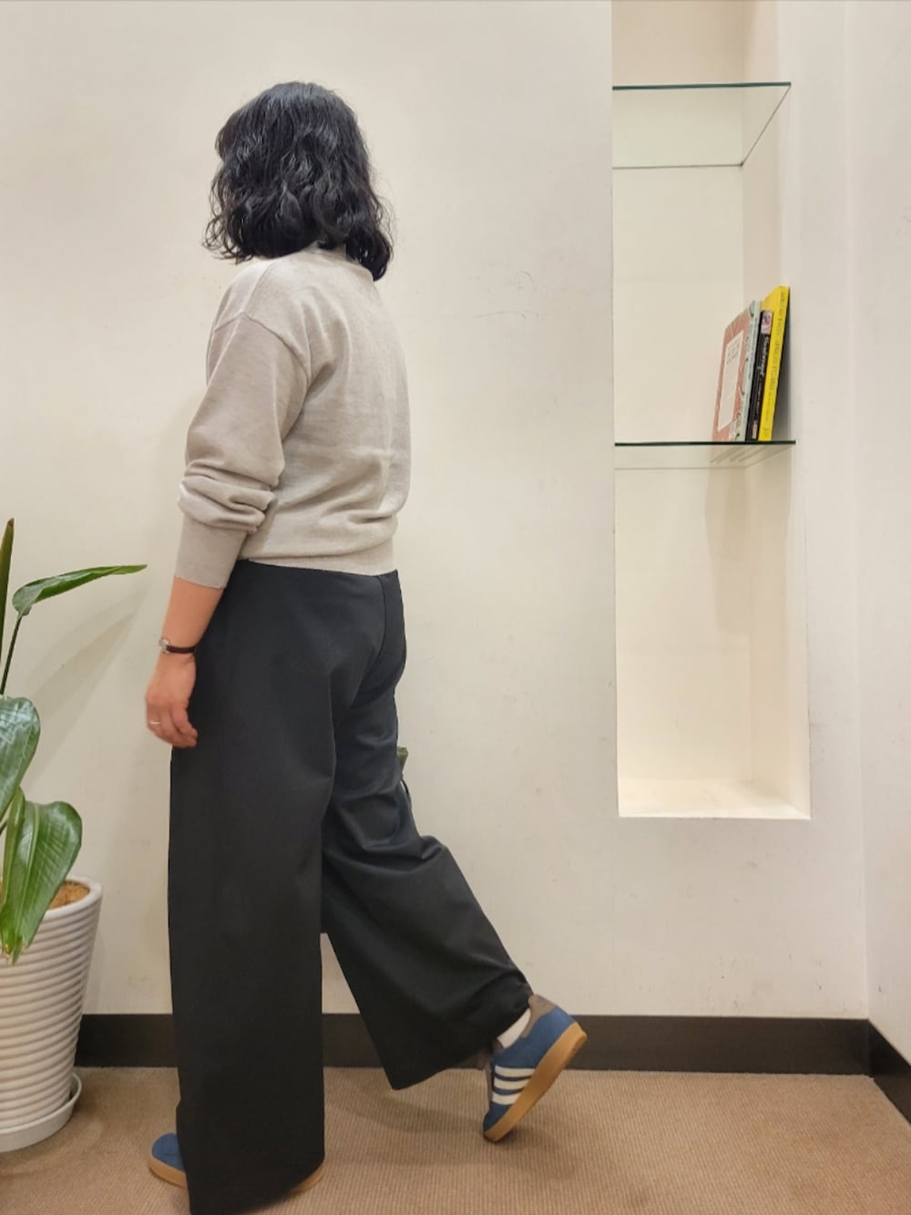 グリーン系のトートバッグ、ブルー系のスニーカー、ブラック系のその他パンツを着用したレディースの秋コーディネートの4枚目の写真