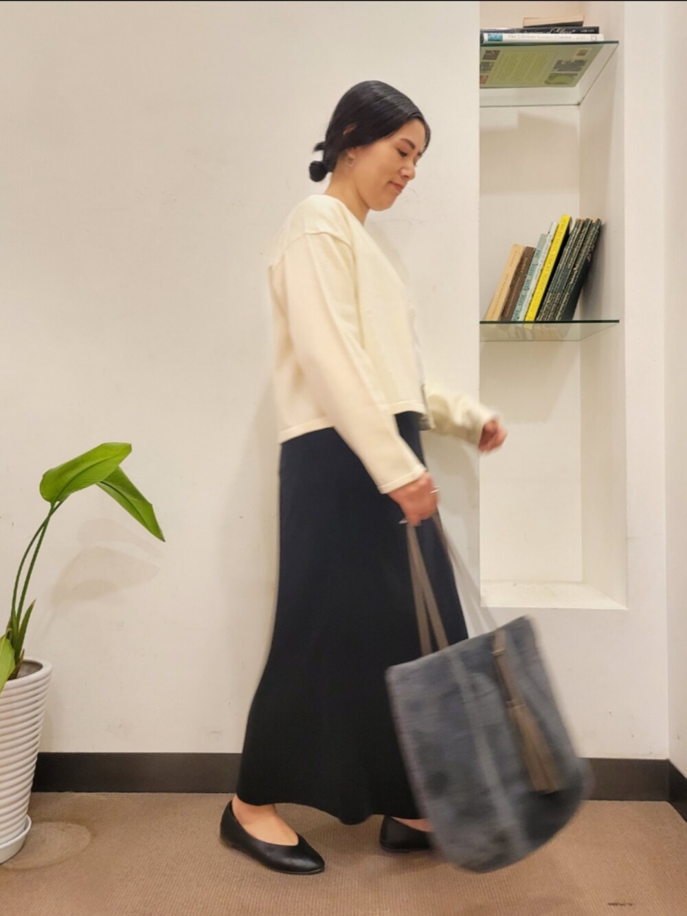 ブラック系のパンプス、グレー系のトートバッグ、ホワイト系のカーディガン/ボレロを着用したレディースの秋コーディネートの3枚目の写真