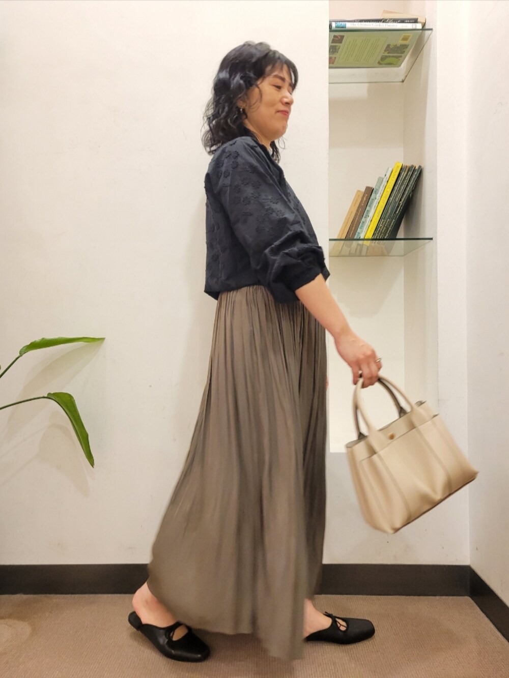 ベージュ系のスカート、ブラック系のシャツ/ブラウス、ブラック系のサンダルを着用したレディースの秋コーディネートの4枚目の写真