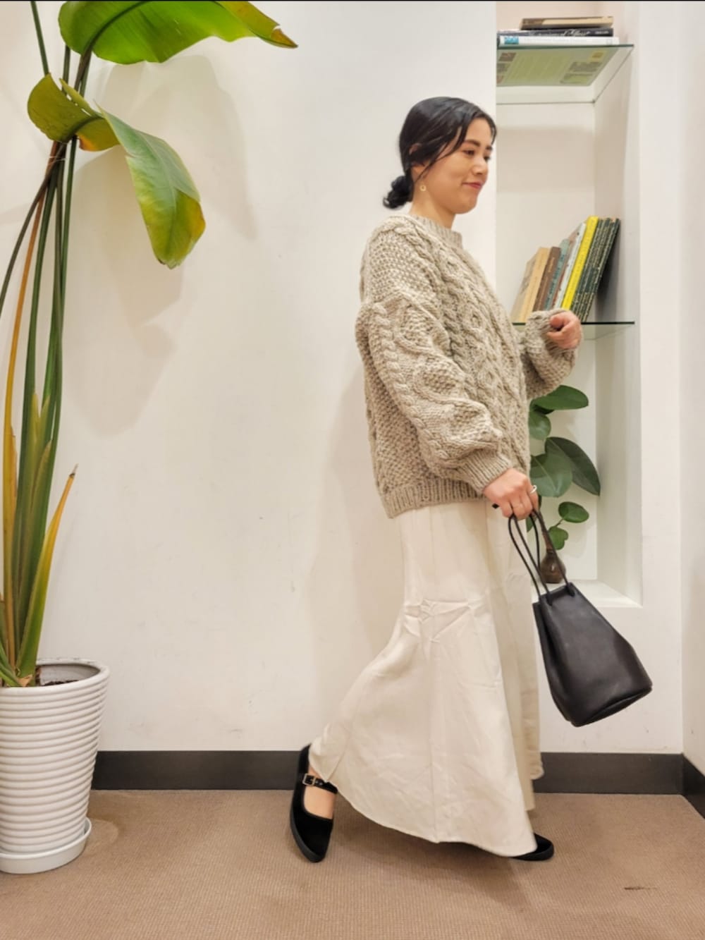 ホワイト系のスカート、グレー系のニット/セーターを着用したレディースの秋コーディネートの3枚目の写真