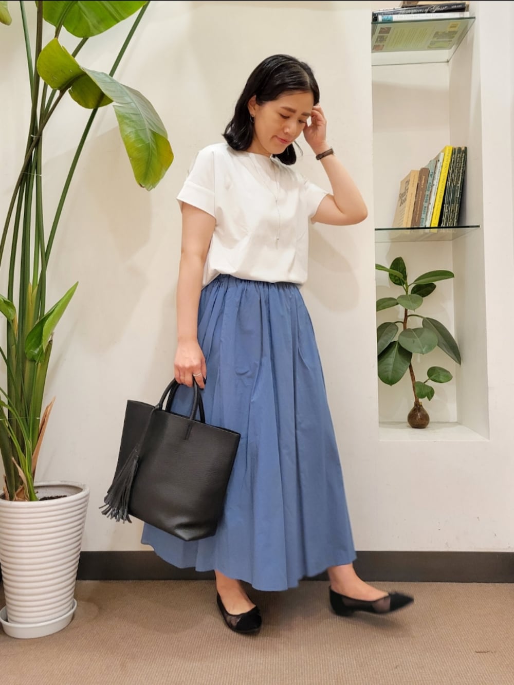 ブラック系のバレエシューズ、ブラック系のトートバッグ、ブルー系のスカートを着用したレディースの夏コーディネートの3枚目の写真