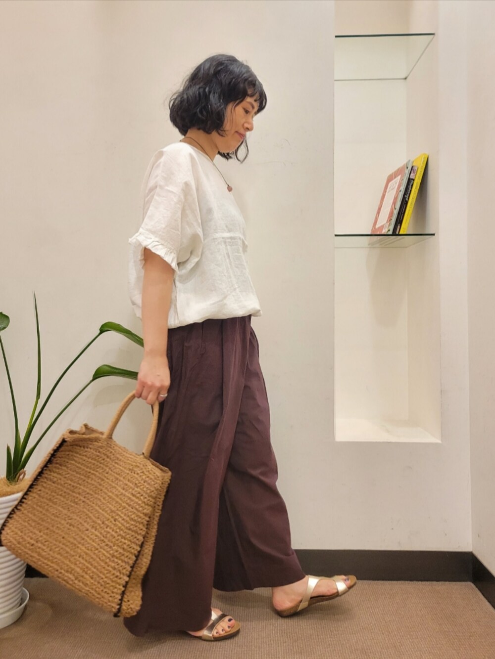 ベージュ系のトートバッグ、ゴールド系のサンダル、ブラウン系のその他パンツを着用したレディースの夏コーディネートの3枚目の写真