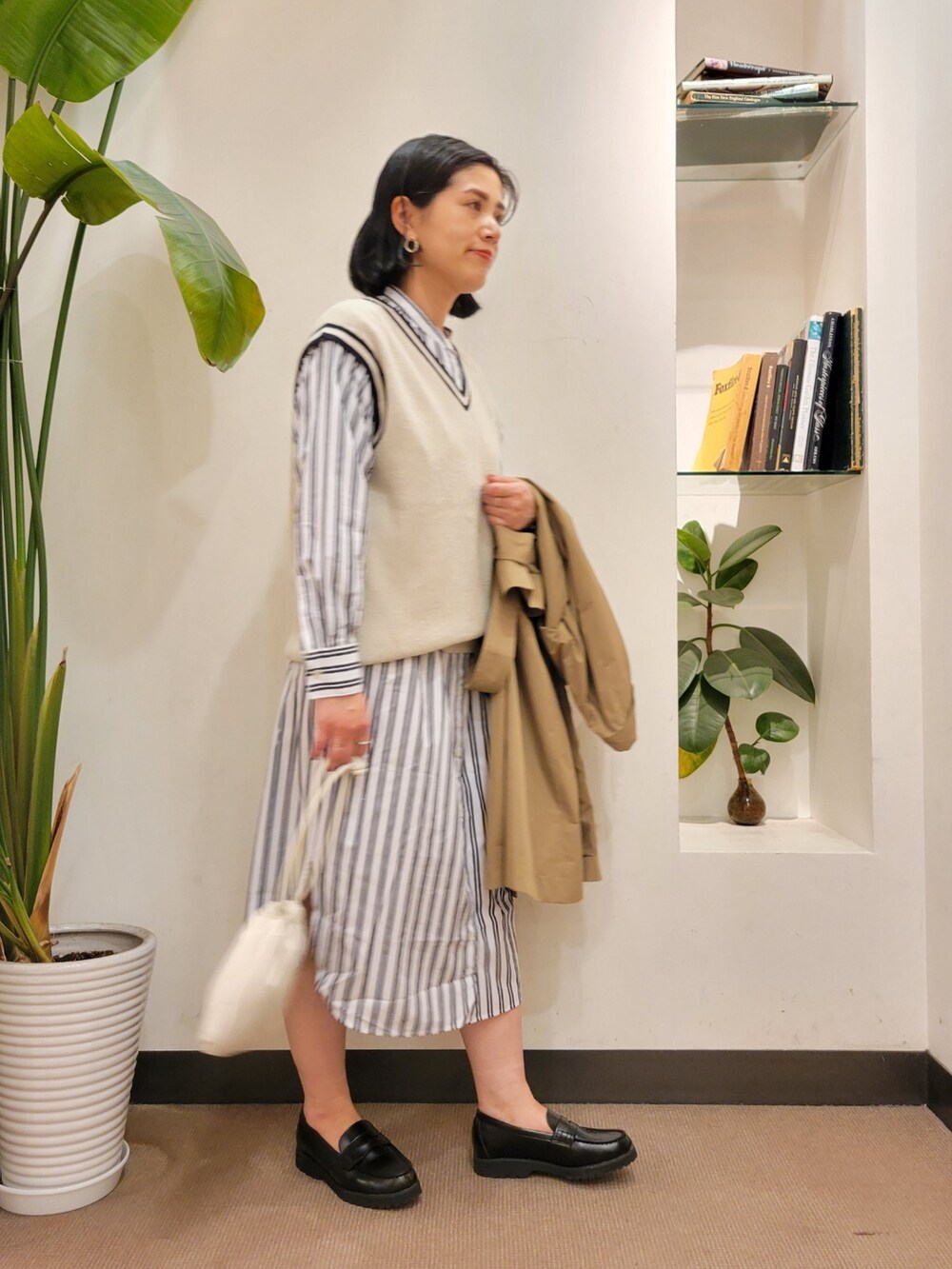 ブラック系のローファー、ブルー系のベスト、ブルー系のワンピースを着用したレディースの春コーディネートの5枚目の写真