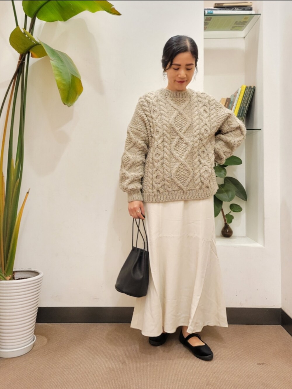 ホワイト系のスカート、グレー系のニット/セーターを着用したレディースの秋コーディネートの2枚目の写真