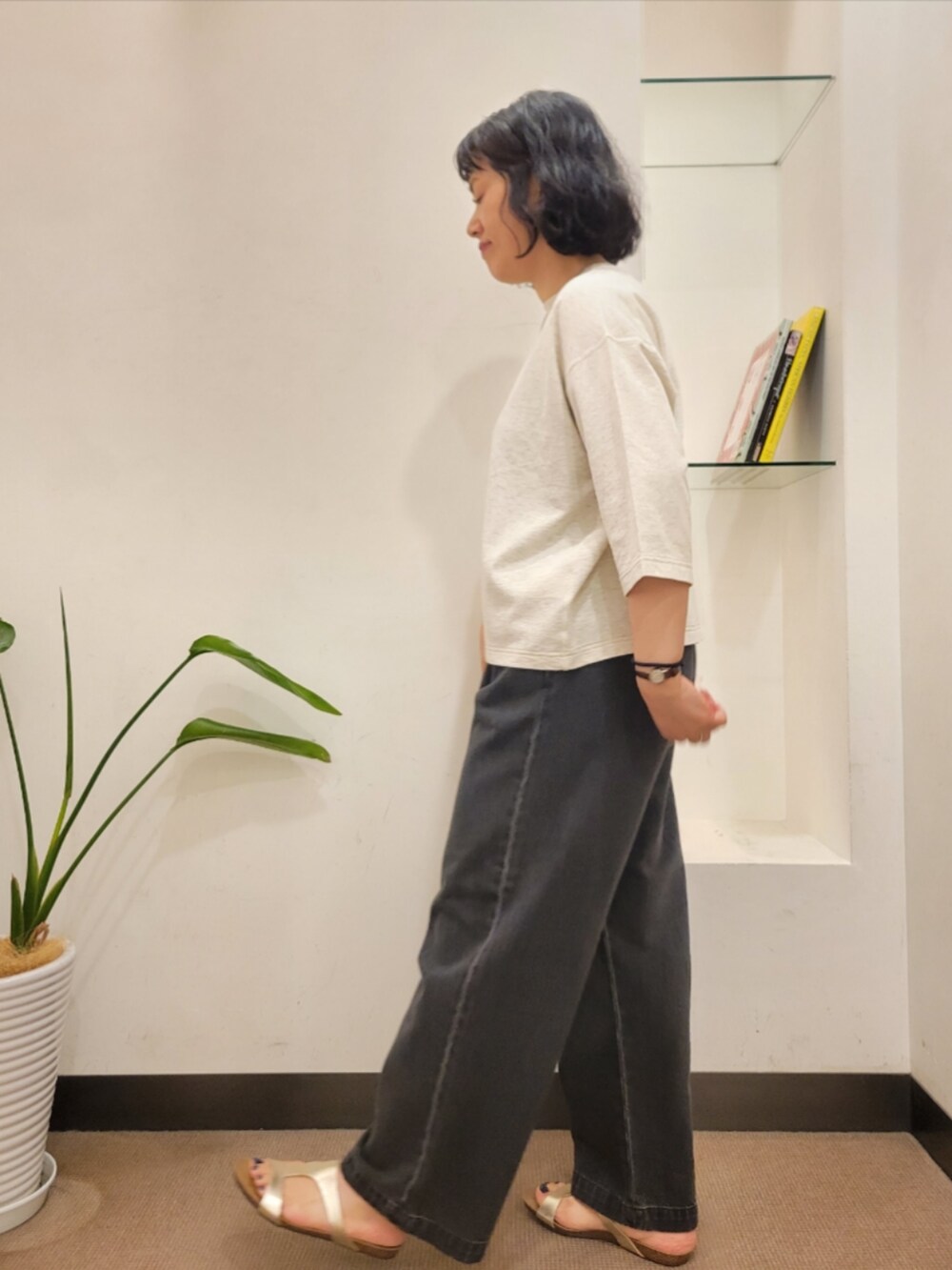ブラウン系のショルダーバッグ、ゴールド系のサンダル、ブラック系のデニムパンツを着用したレディースの夏コーディネートの5枚目の写真