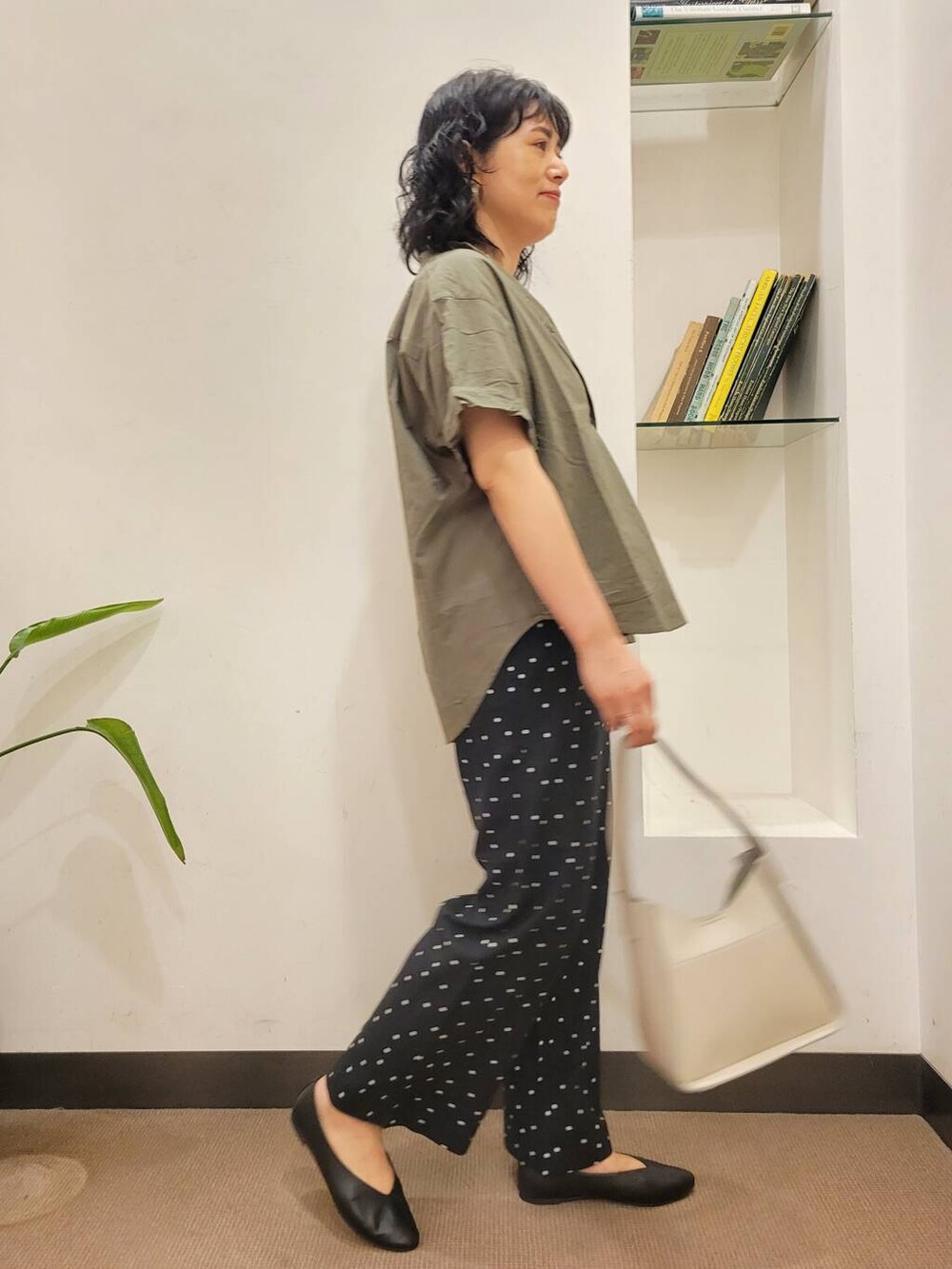ブラック系のパンプス、ブラック系のその他パンツ、グリーン系のシャツ/ブラウスを着用したレディースの夏コーディネートの3枚目の写真