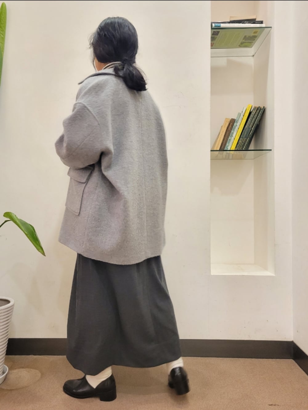 ブラック系のレインシューズ、シルバー系のショルダーバッグ、グレー系のその他アウターを着用したレディースの冬コーディネートの3枚目の写真