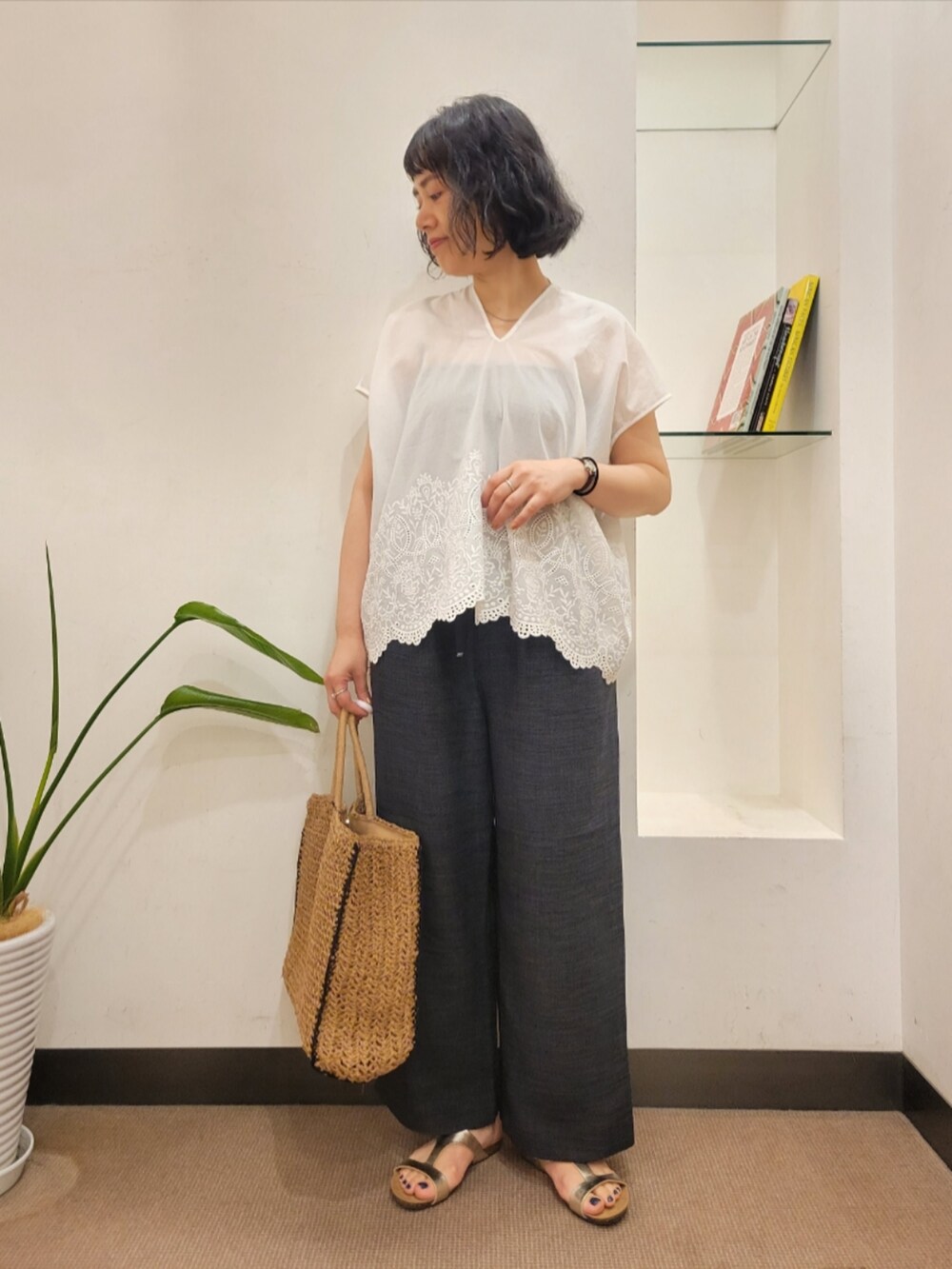 グレー系のその他パンツ、ホワイト系のシャツ/ブラウス、ベージュ系のトートバッグを着用したレディースの夏コーディネートの2枚目の写真