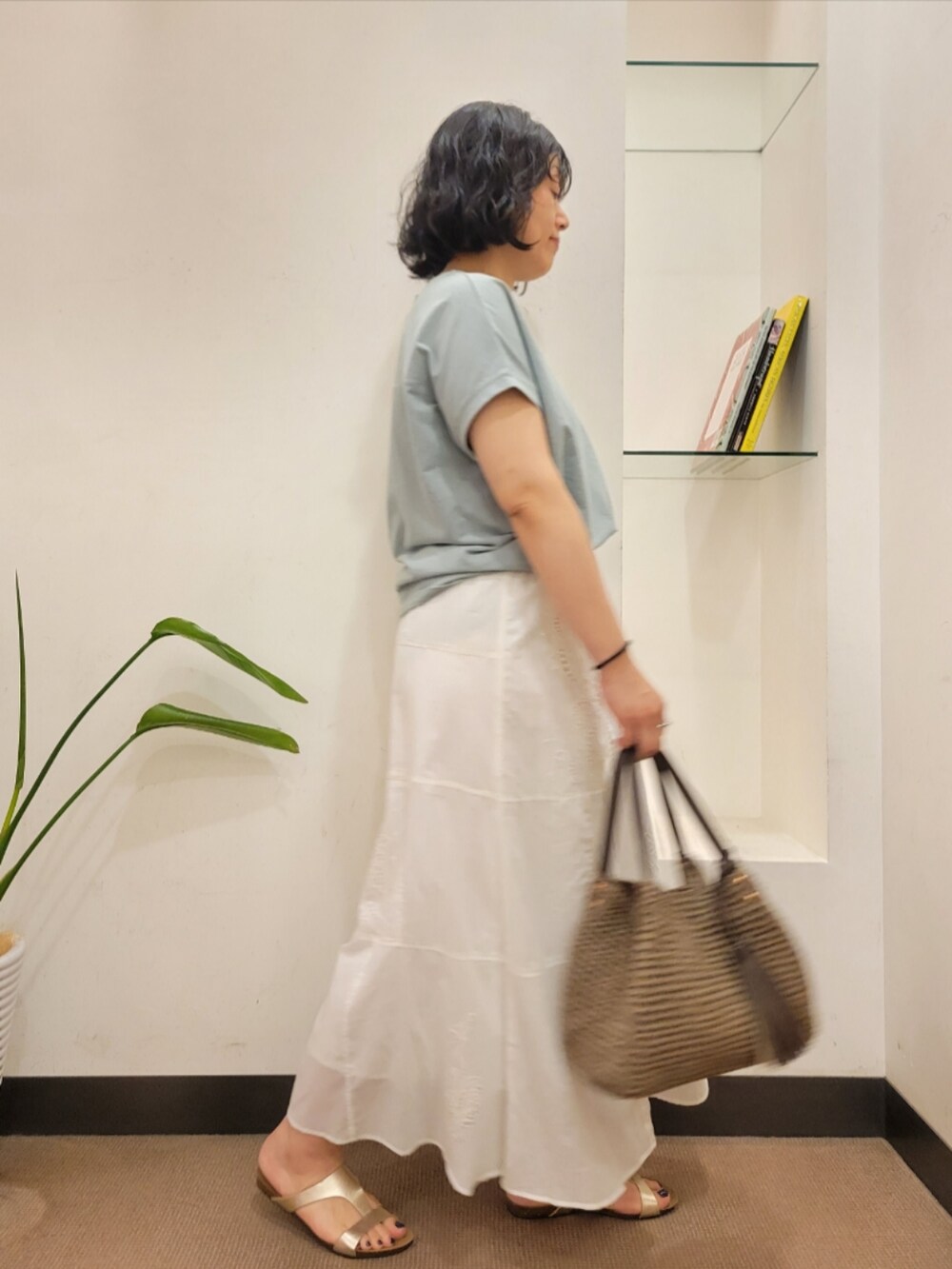 ホワイト系のスカート、グリーン系のTシャツ/カットソー、グレー系のかごバッグを着用したレディースの夏コーディネートの2枚目の写真