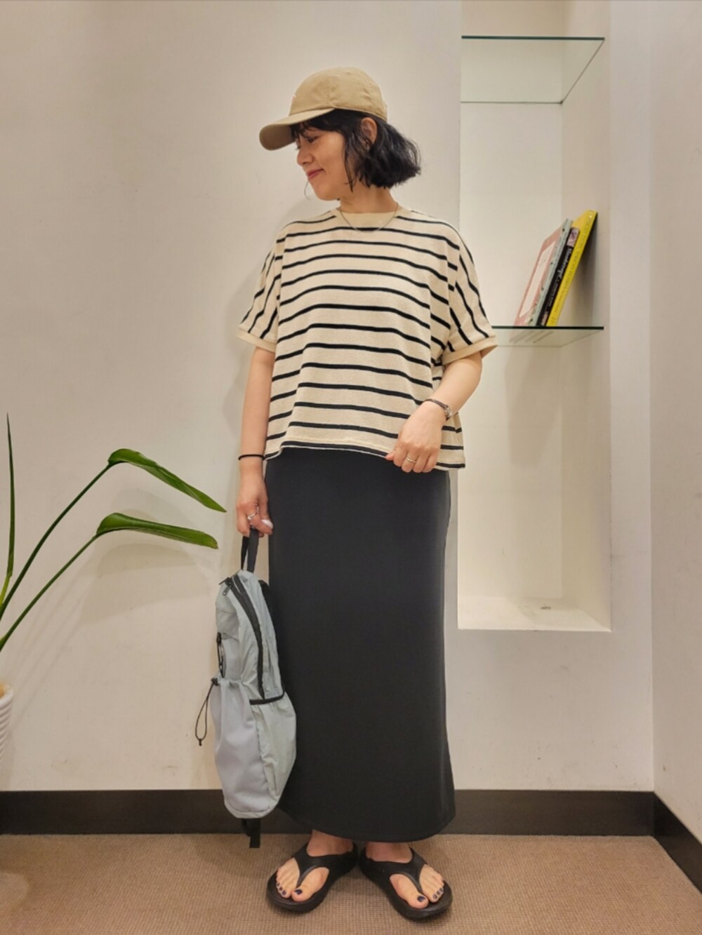 ブルー系のバックパック/リュック、ホワイト系のTシャツ/カットソー、ブラック系のスカートを着用したレディースの夏コーディネートの2枚目の写真