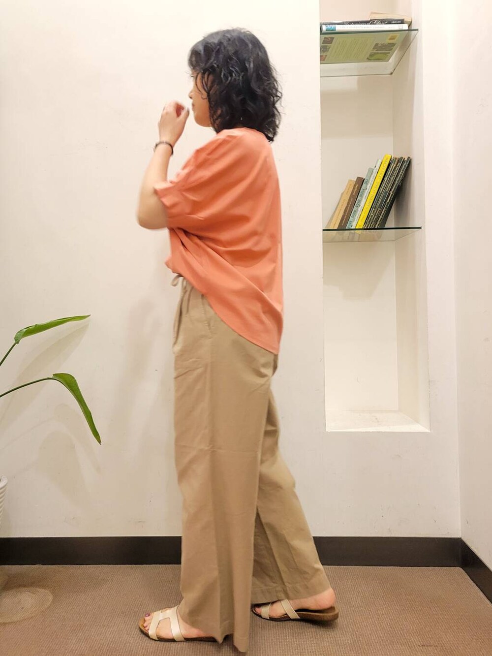 オレンジ系のTシャツ/カットソー、ブラック系のショルダーバッグ、ホワイト系のサンダルを着用したレディースの夏コーディネートの5枚目の写真