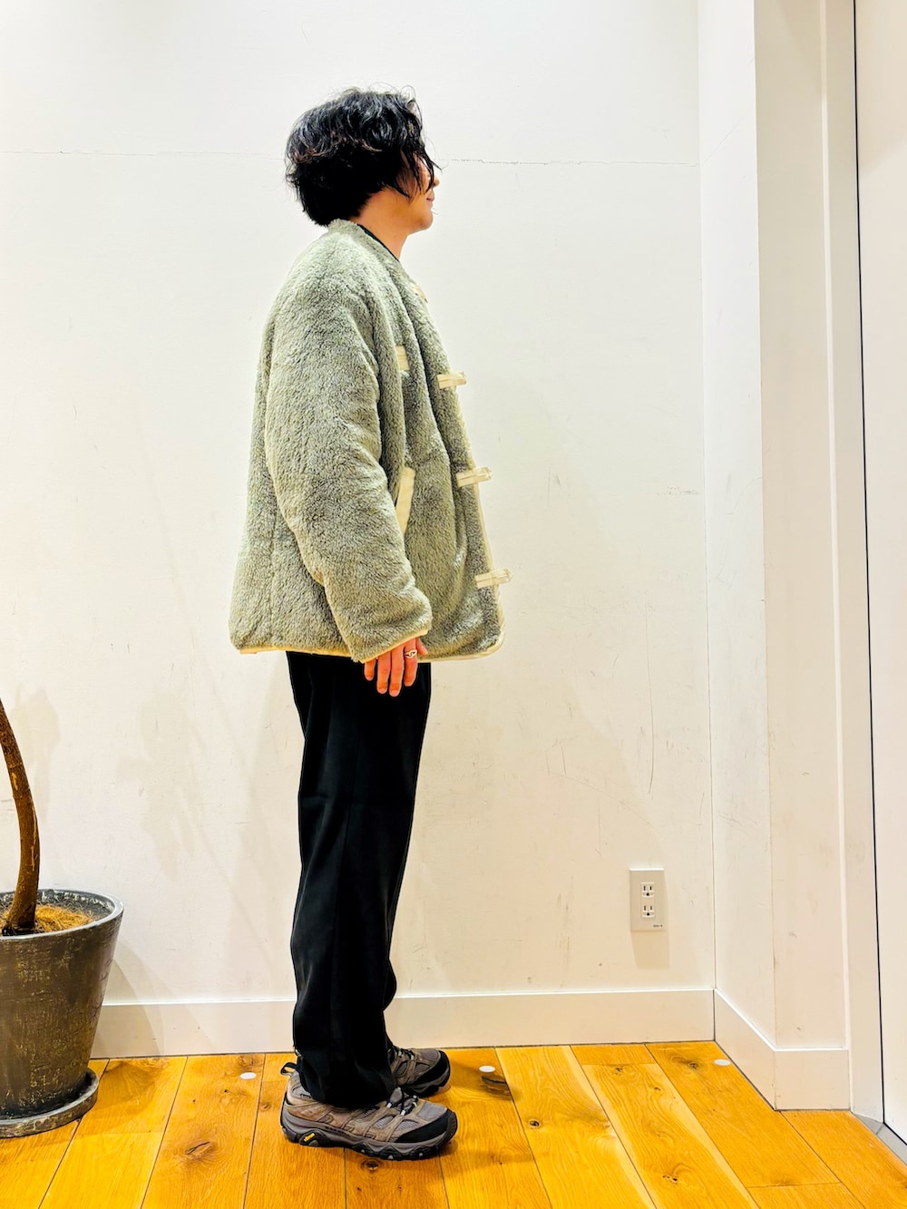 グリーン系のニット/セーター、ブラック系のその他パンツ、ホワイト系のその他アウターを着用したメンズの冬コーディネートの3枚目の写真