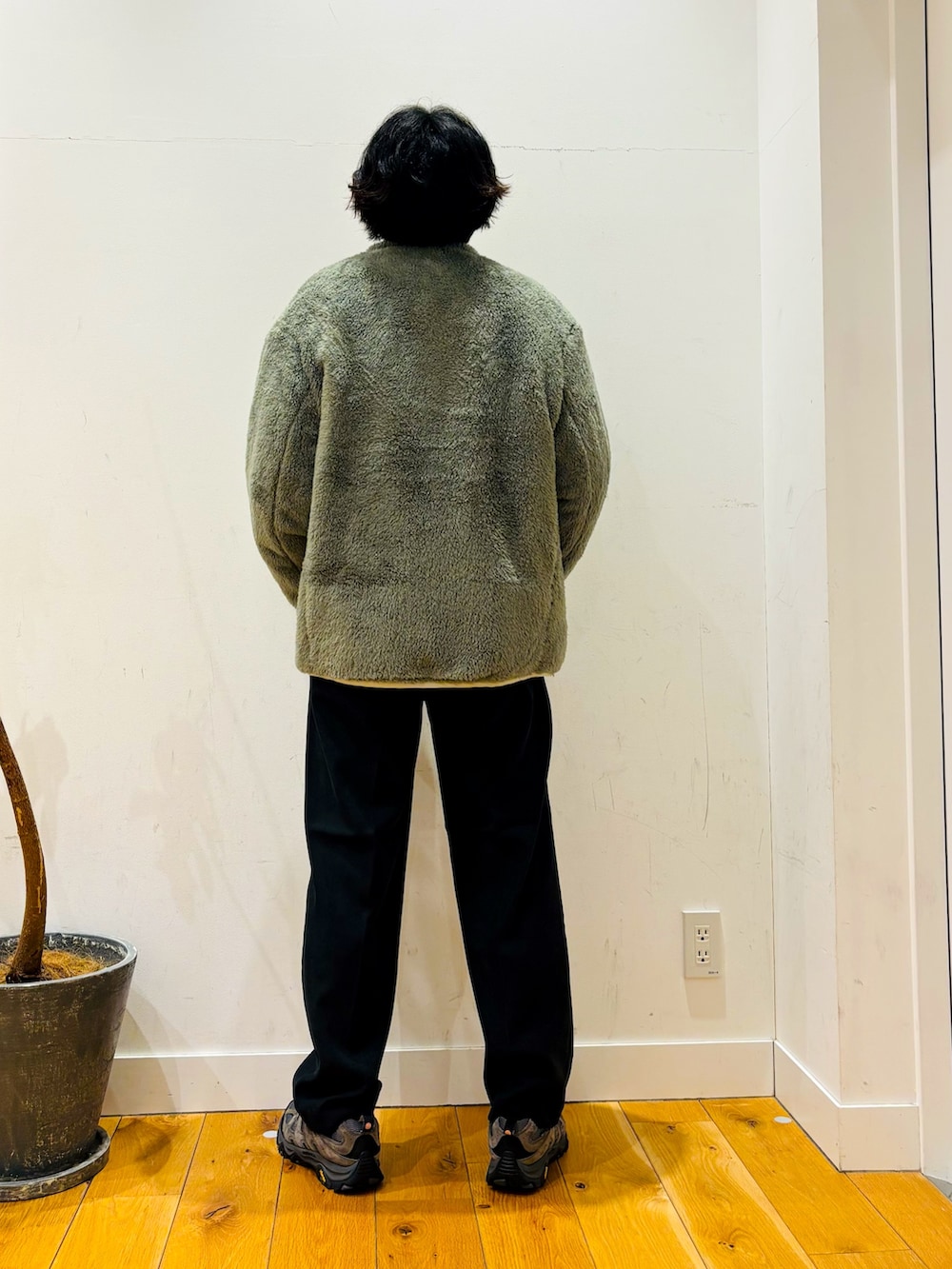 グリーン系のニット/セーター、ブラック系のその他パンツ、ホワイト系のその他アウターを着用したメンズの冬コーディネートの4枚目の写真