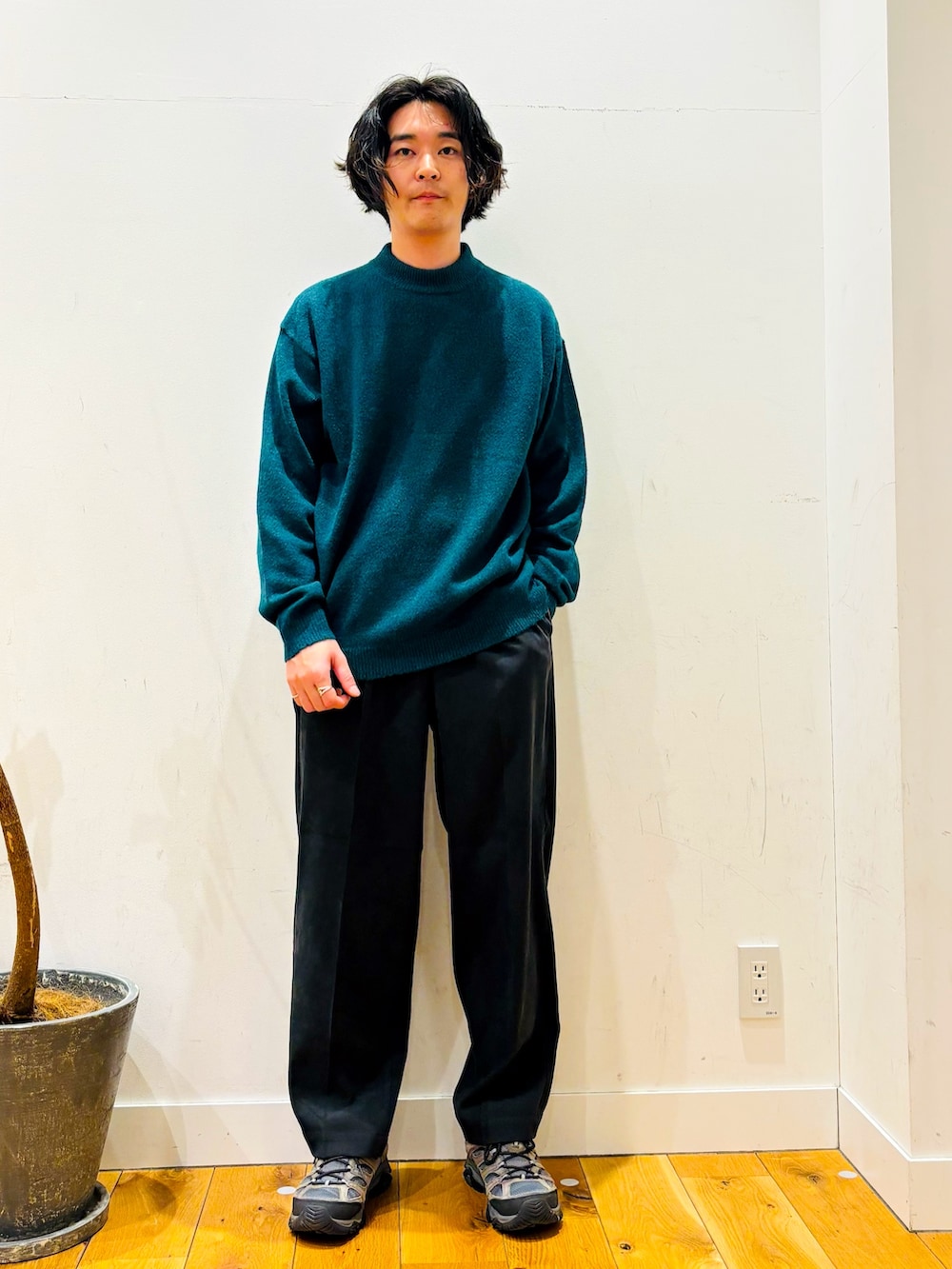 グリーン系のニット/セーター、ブラック系のその他パンツ、ホワイト系のその他アウターを着用したメンズの冬コーディネートの5枚目の写真