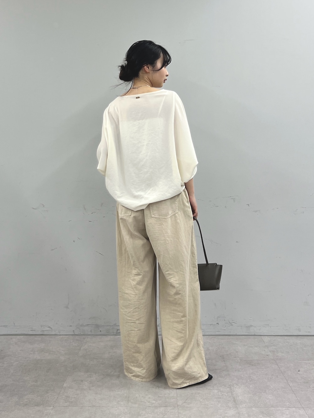 ベージュ系のその他パンツ、ホワイト系のシャツ/ブラウス、グレー系のハンドバッグを着用したレディースの春コーディネートの3枚目の写真