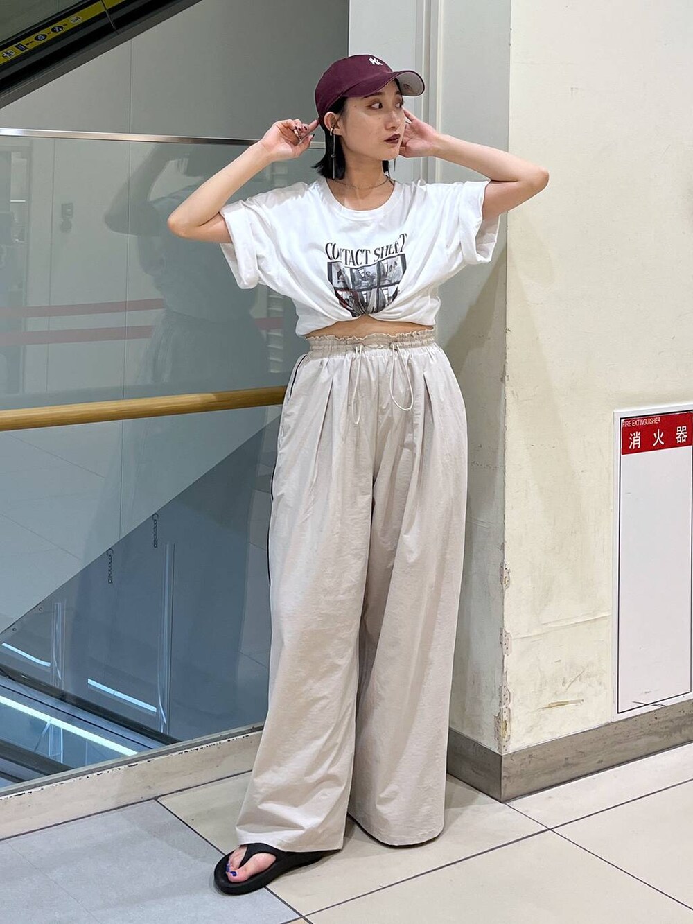 ホワイト系のTシャツ/カットソー、ブラック系のサンダル、ベージュ系のその他パンツを着用したレディースの夏コーディネートの2枚目の写真