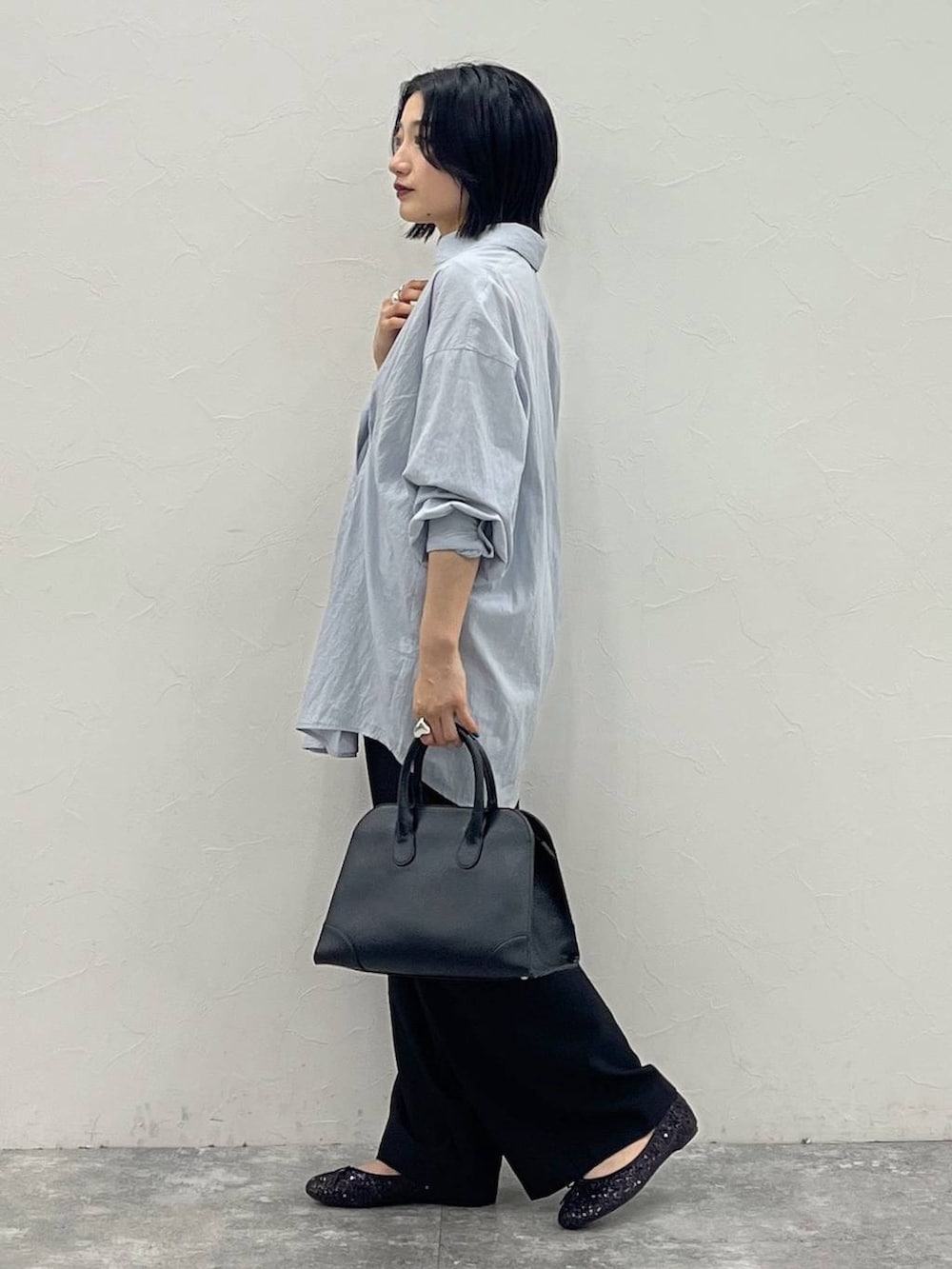 ブラック系のバレエシューズ、ブラック系のショルダーバッグ、ブルー系のシャツ/ブラウスを着用したレディースの夏コーディネートの5枚目の写真