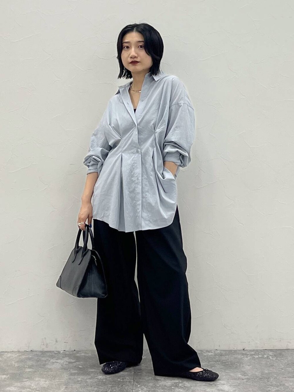 ブラック系のバレエシューズ、ブラック系のショルダーバッグ、ブルー系のシャツ/ブラウスを着用したレディースの夏コーディネートの3枚目の写真