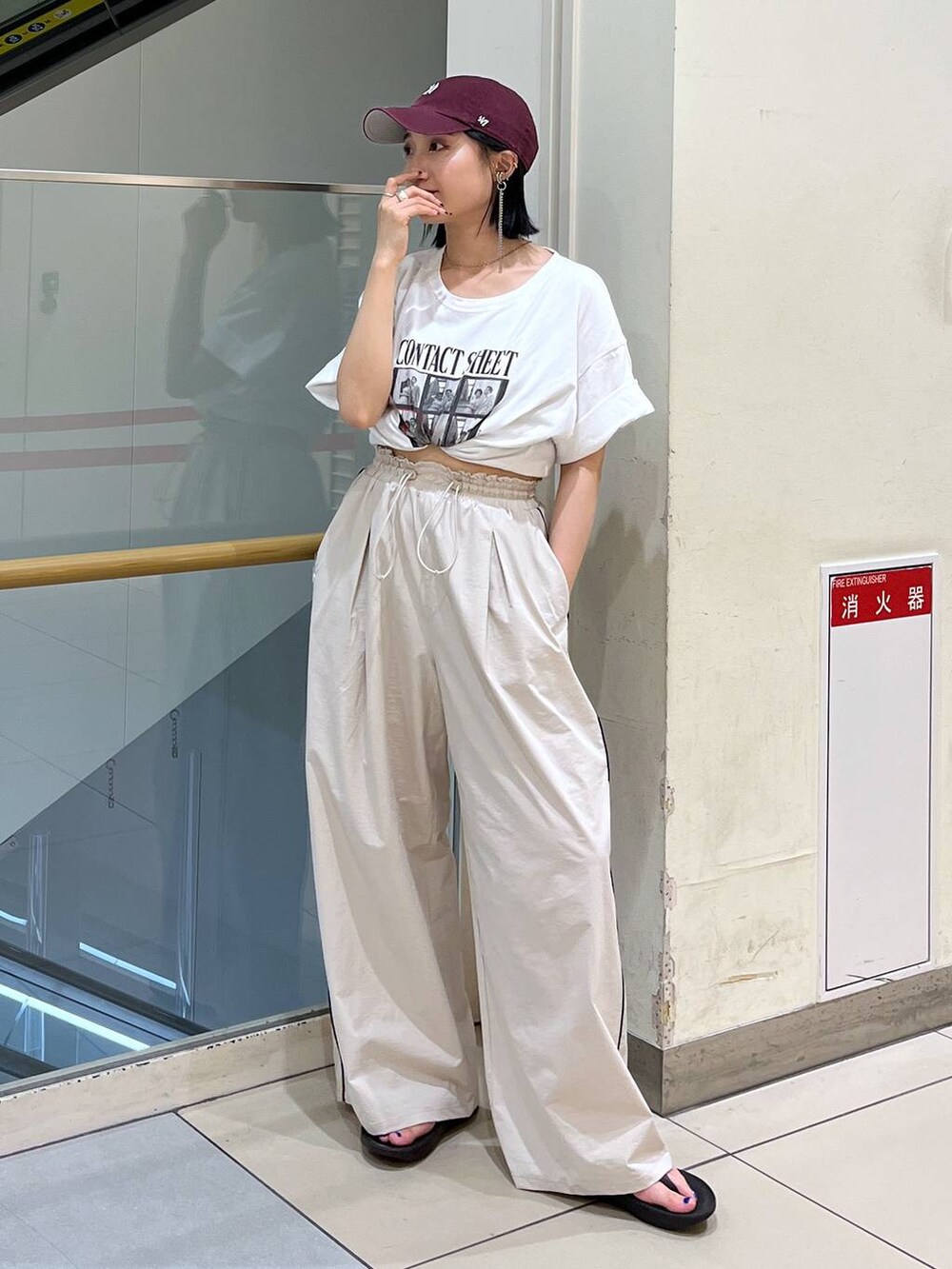 ホワイト系のTシャツ/カットソー、ブラック系のサンダル、ベージュ系のその他パンツを着用したレディースの夏コーディネートの3枚目の写真