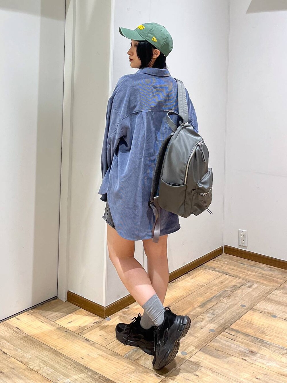 グレー系のバックパック/リュック、ブルー系のシャツ/ブラウス、ブラック系のスニーカーを着用したレディースの秋コーディネートの5枚目の写真