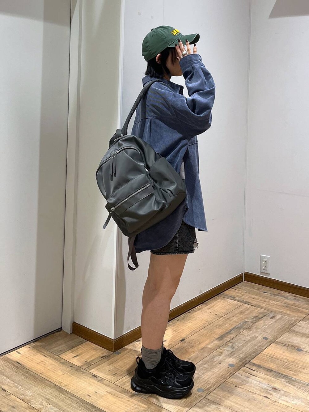 グレー系のバックパック/リュック、ブルー系のシャツ/ブラウス、ブラック系のスニーカーを着用したレディースの秋コーディネートの6枚目の写真