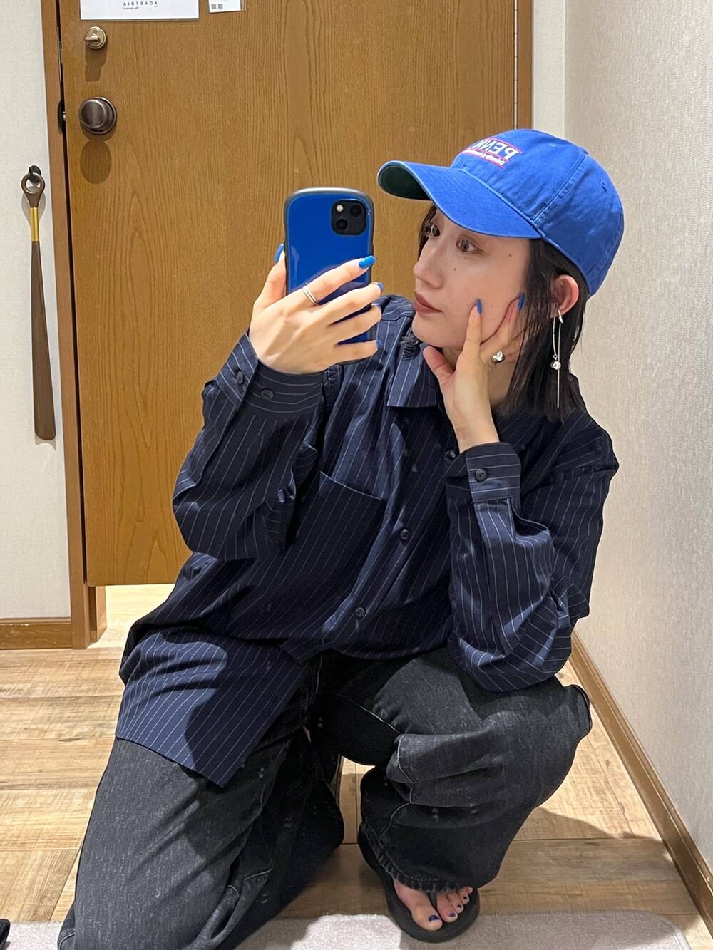 ブラック系のデニムパンツ、ブルー系のシャツ/ブラウス、ブルー系のハットを着用したレディースの秋コーディネートの2枚目の写真